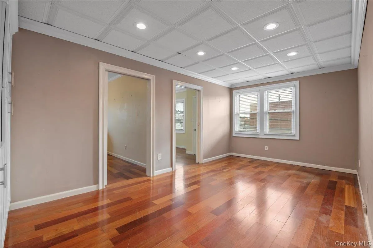 Spare room with recessed lighting, crown molding, light wood finished floors, and coffered ceiling Spare room with recessed lighting, crown molding, light wood finished floors, and coffered ceiling