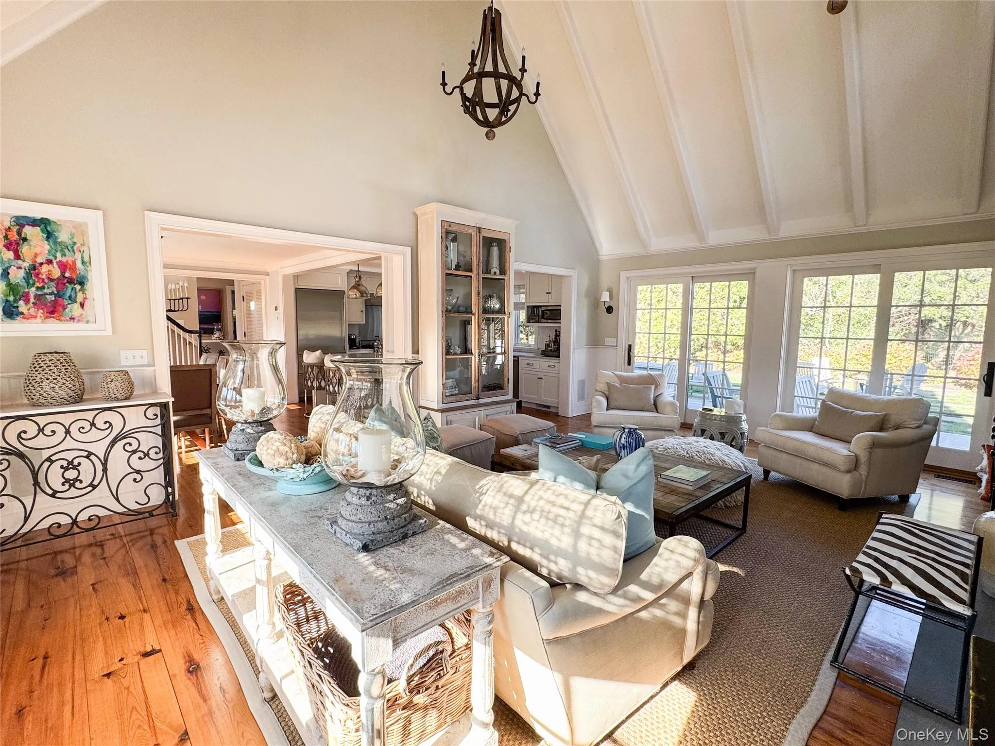 Living room featuring high vaulted ceiling, beamed ceiling, a chandelier, and dark wood finished floors Living room featuring high vaulted ceiling, beamed ceiling, a chandelier, and dark wood finished floors