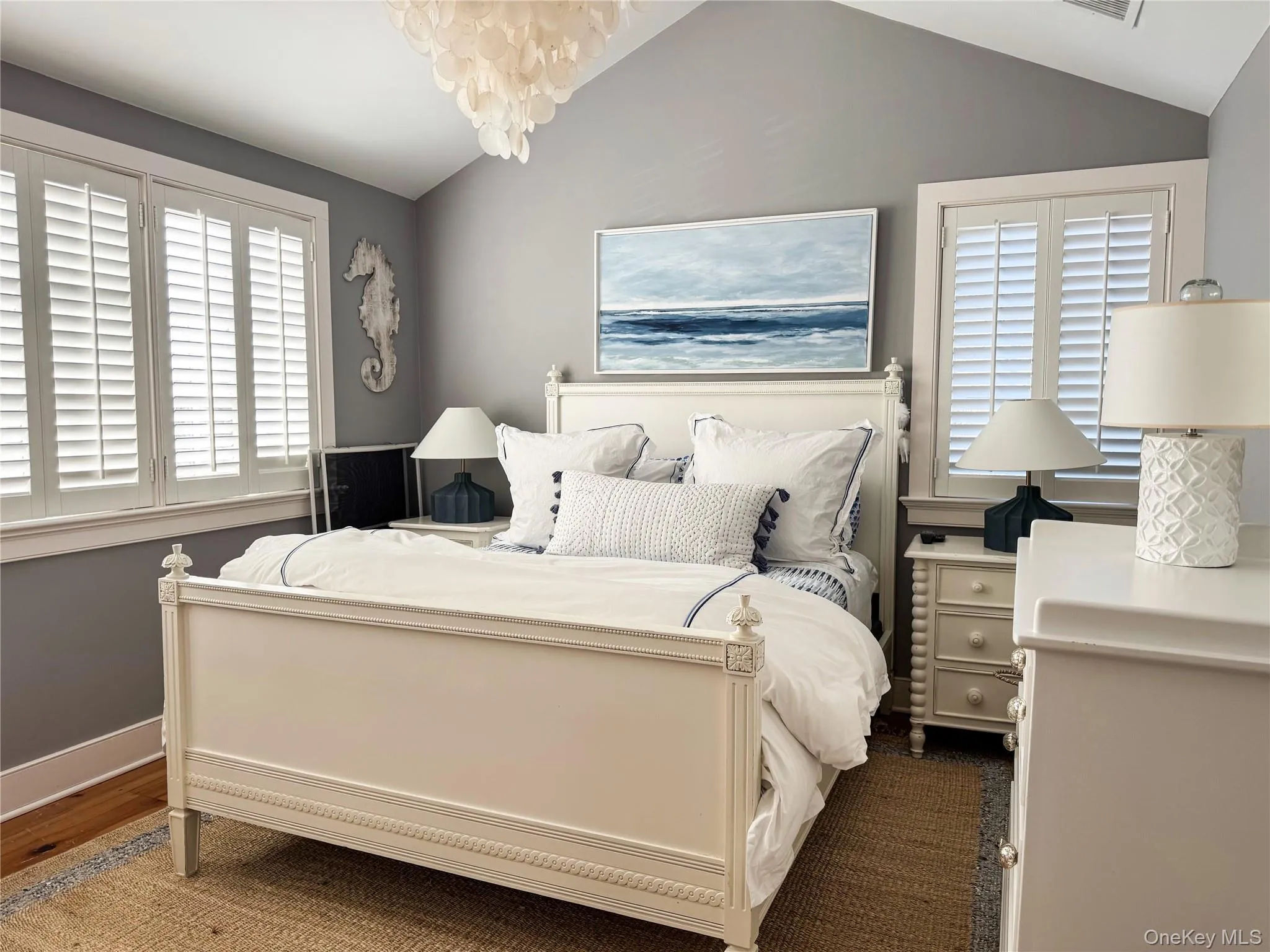Bedroom featuring vaulted ceiling, multiple windows, a chandelier, and dark wood finished floors Bedroom featuring vaulted ceiling, multiple windows, a chandelier, and dark wood finished floors