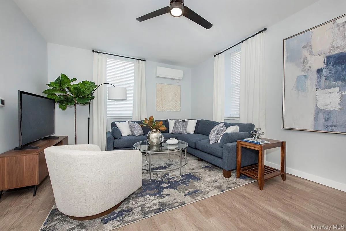 Living area with healthy amount of natural light, wood finished floors, and ceiling fan Living area with healthy amount of natural light, wood finished floors, and ceiling fan