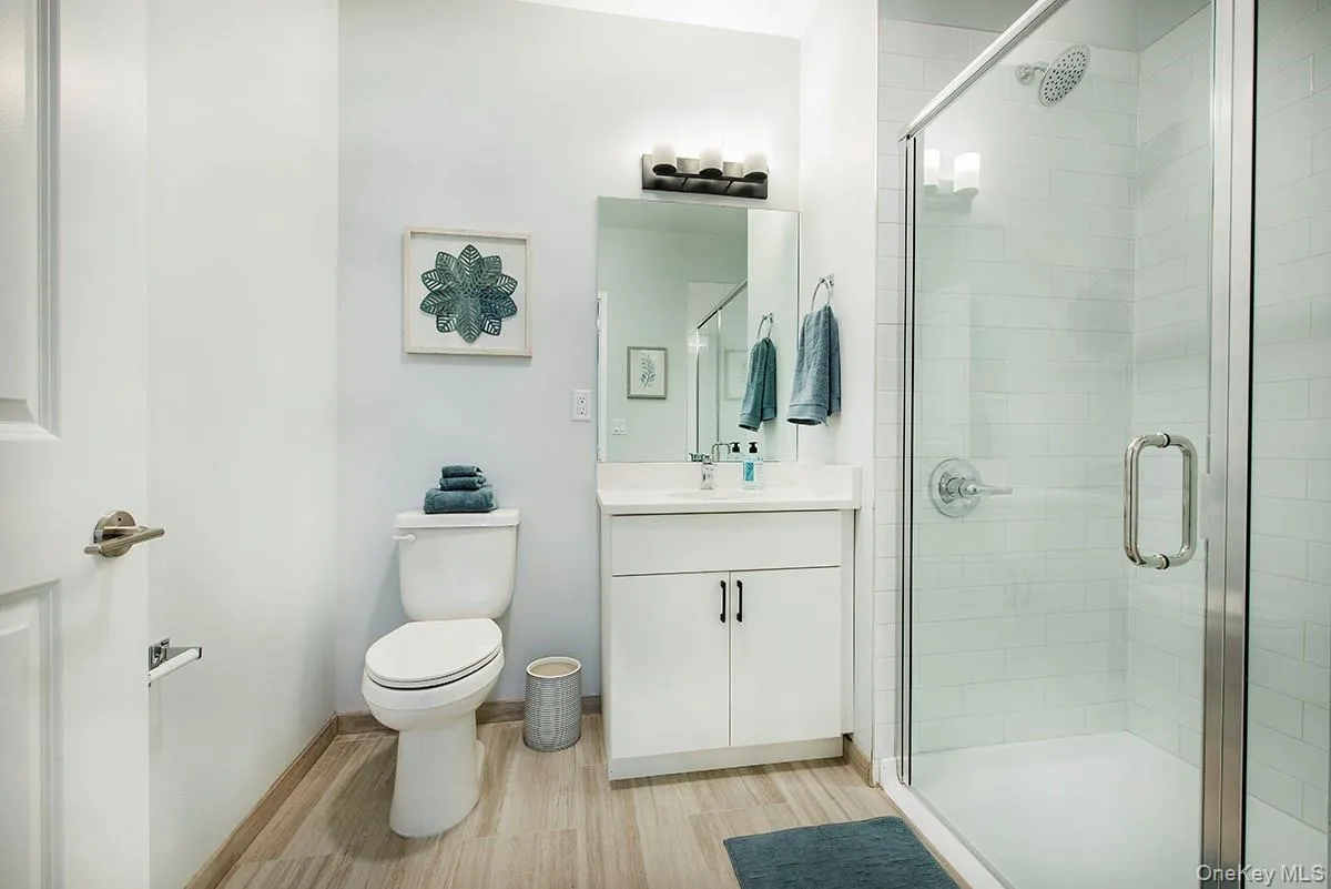Bathroom with vanity, a shower stall, and light wood-type flooring Bathroom with vanity, a shower stall, and light wood-type flooring