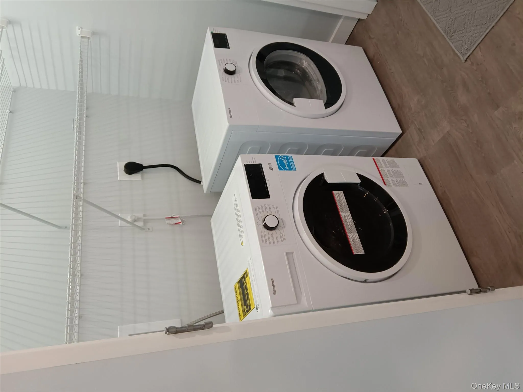 Laundry area featuring separate washer and dryer and wood finished floors Laundry area featuring separate washer and dryer and wood finished floors