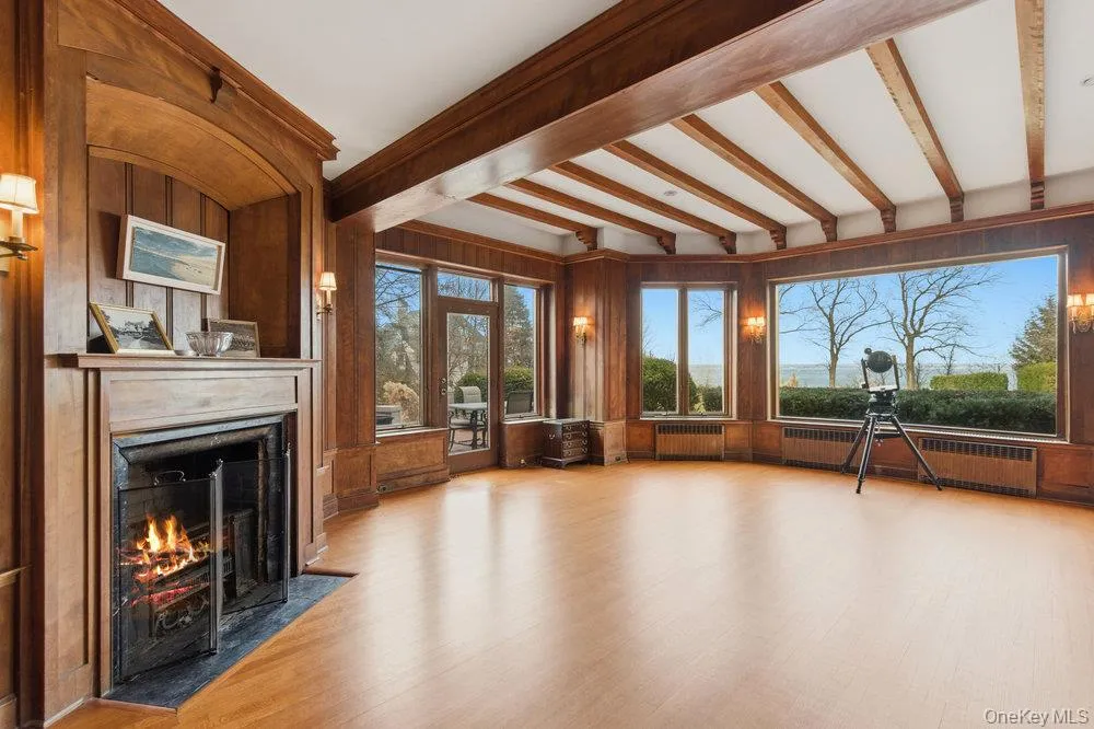 Formal living room with hardwood floors and fireplace. Overlooks backyard and Long Island sound Formal living room with hardwood floors and fireplace. Overlooks backyard and Long Island sound