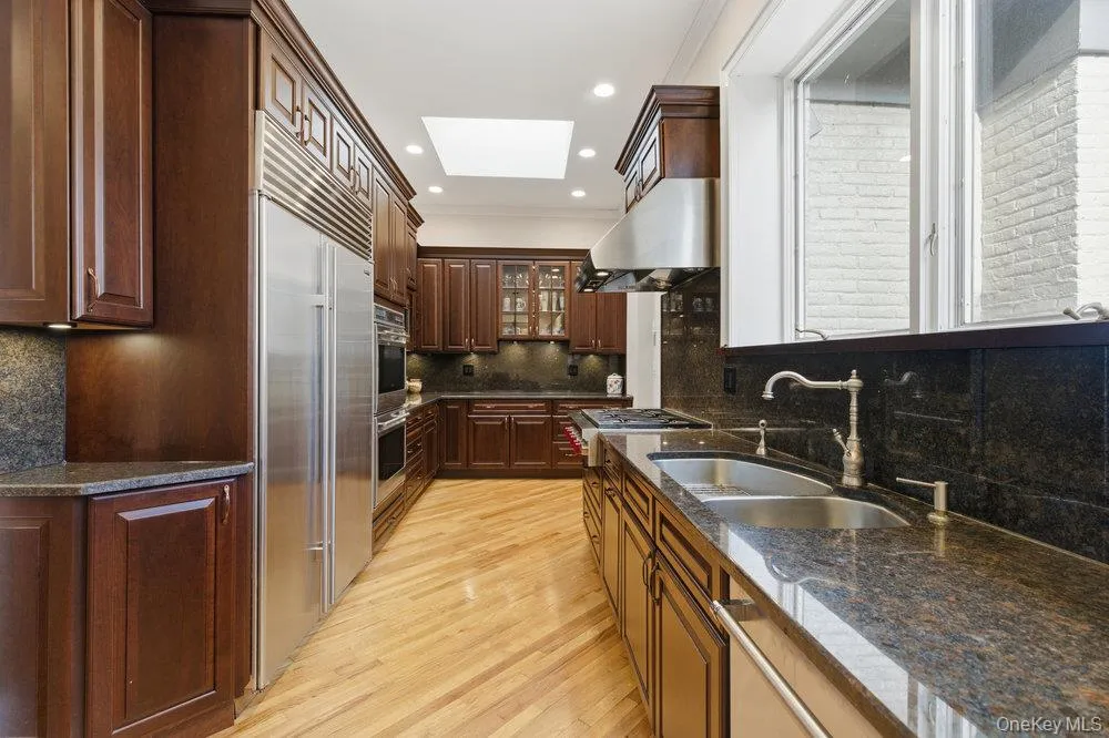 Kitchen with skylight, hardwood floors, stone counters, and hi end stainless steel appliances Kitchen with skylight, hardwood floors, stone counters, and hi end stainless steel appliances