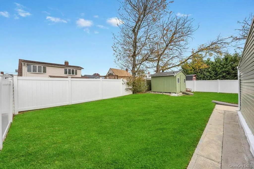 Fenced backyard featuring a storage unit Fenced backyard featuring a storage unit