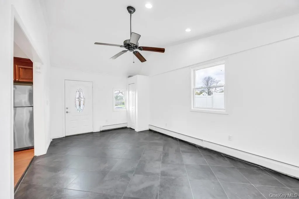 Foyer entrance featuring a baseboard radiator, healthy amount of natural light, a ceiling fan, and recessed lighting Foyer entrance featuring a baseboard radiator, healthy amount of natural light, a ceiling fan, and recessed lighting