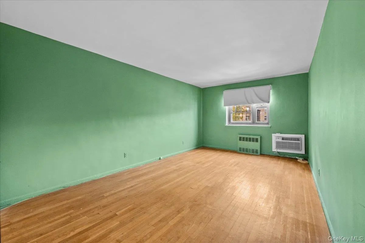 Spare room featuring wood-type flooring and radiator Spare room featuring wood-type flooring and radiator