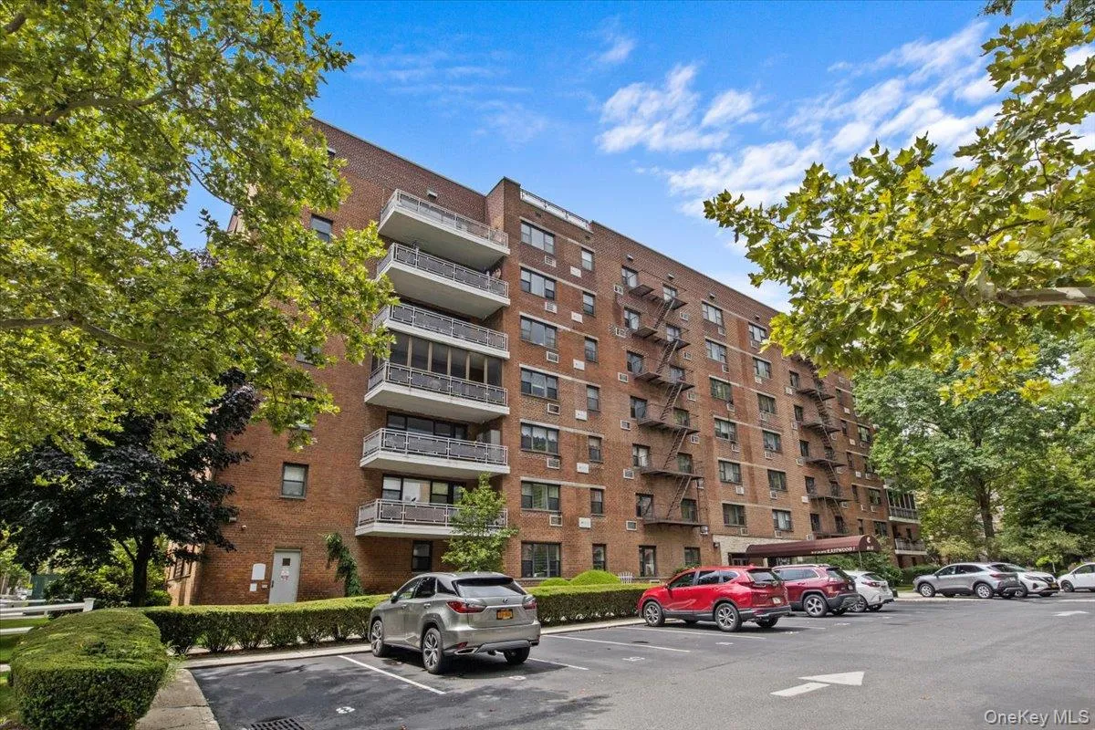 View of apartment building / complex with uncovered parking View of apartment building / complex with uncovered parking