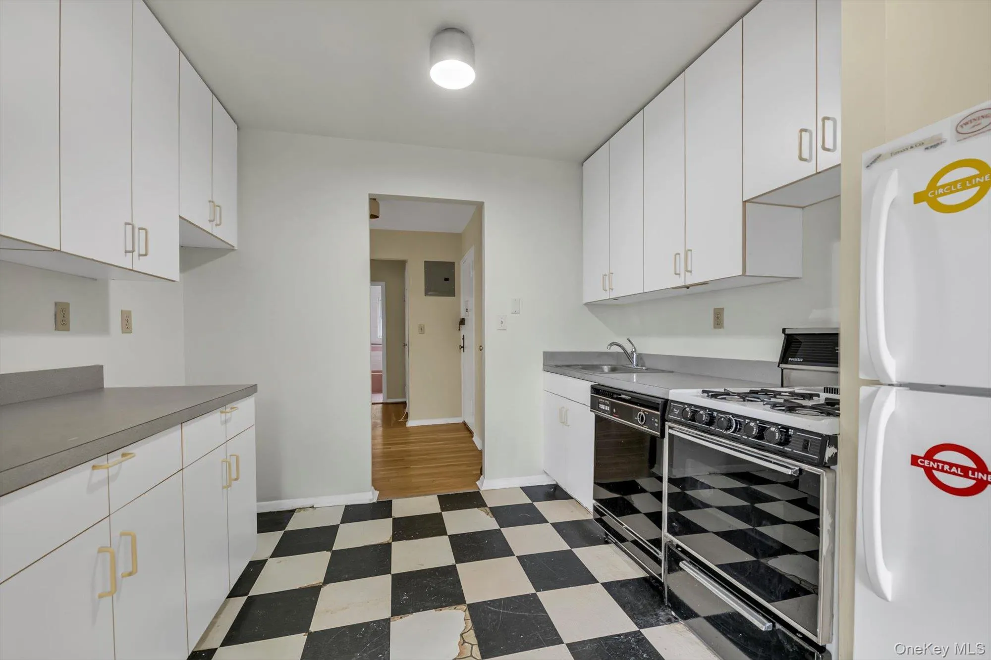 Kitchen featuring gas stove, freestanding refrigerator, white cabinets, dishwasher, and light flooring Kitchen featuring gas stove, freestanding refrigerator, white cabinets, dishwasher, and light flooring
