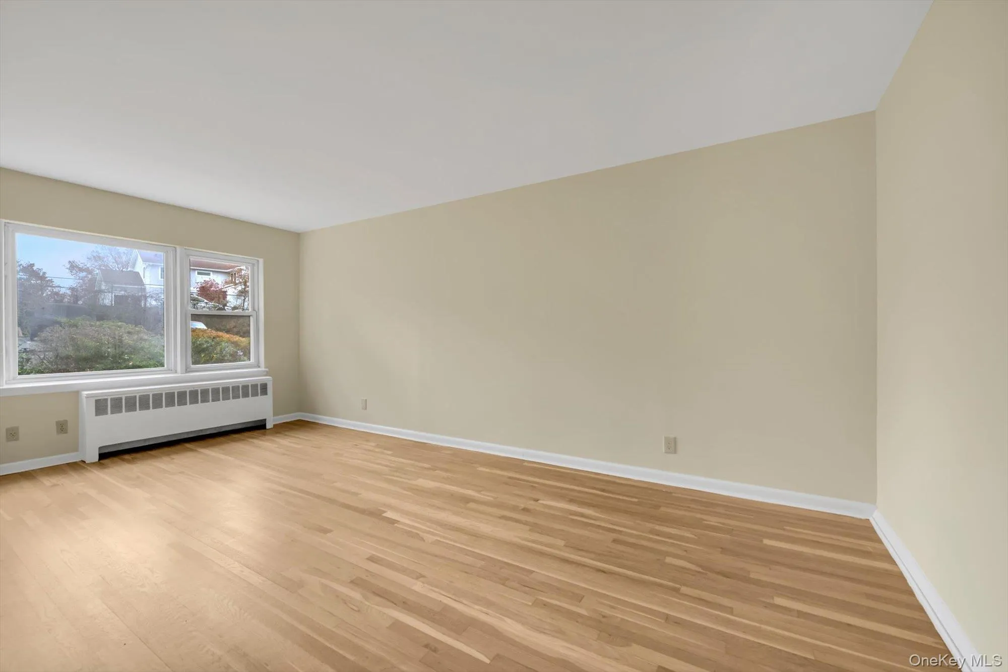 Spare room with radiator and light wood-style flooring Spare room with radiator and light wood-style flooring