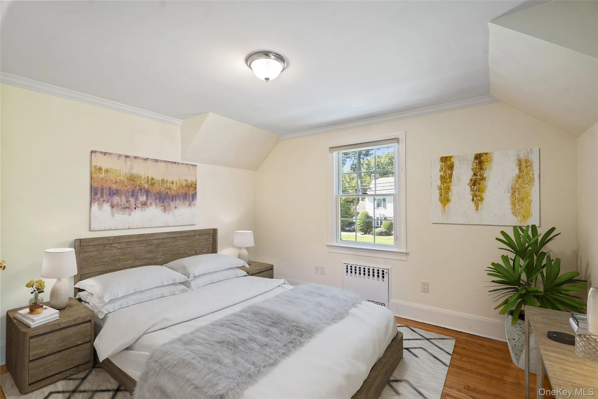 Bedroom with lofted ceiling, radiator heating unit, wood finished floors, and ornamental molding Bedroom with lofted ceiling, radiator heating unit, wood finished floors, and ornamental molding