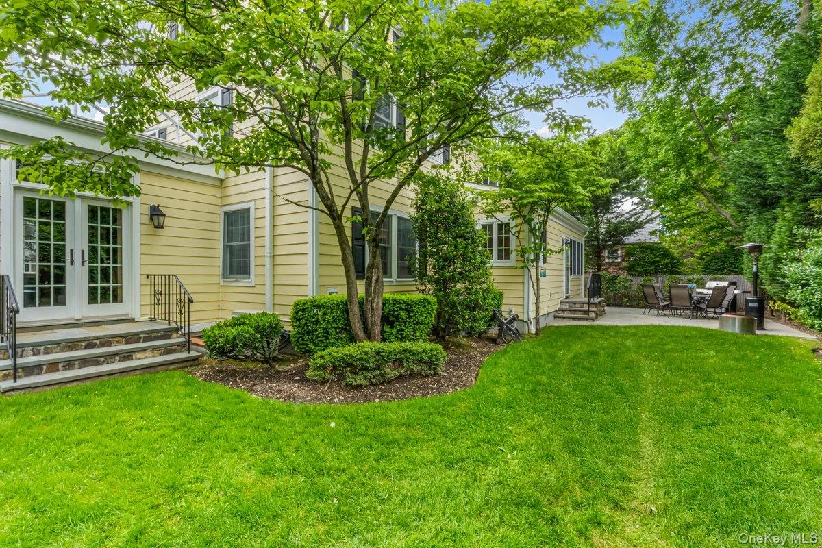 View of grassy yard featuring entry steps, a patio area, and french doors View of grassy yard featuring entry steps, a patio area, and french doors