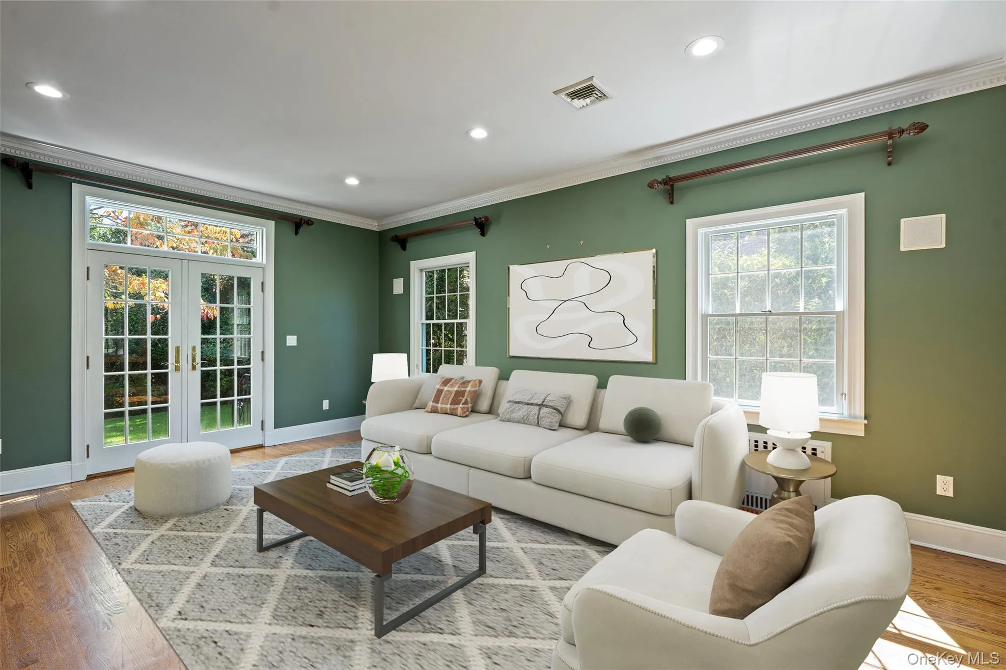 Living room with french doors, wood finished floors, recessed lighting, and crown molding Living room with french doors, wood finished floors, recessed lighting, and crown molding