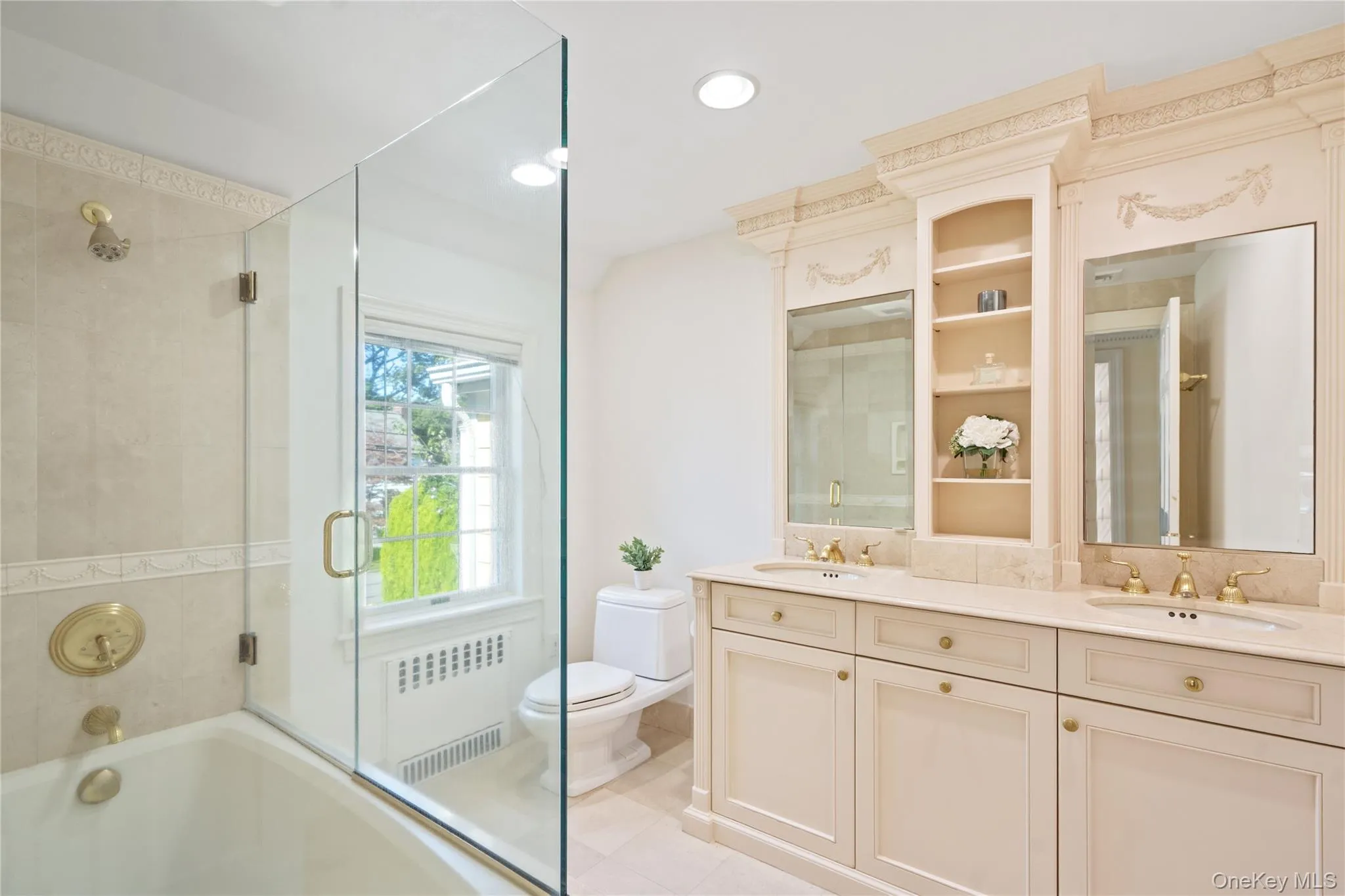 Full bath with radiator heating unit, double vanity, recessed lighting, and light tile patterned flooring Full bath with radiator heating unit, double vanity, recessed lighting, and light tile patterned flooring