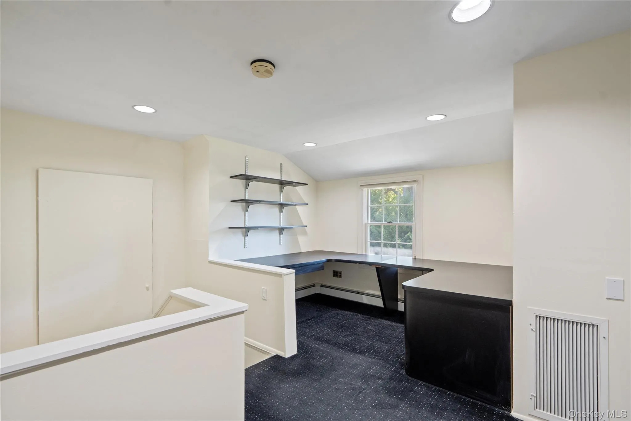 Unfurnished office featuring recessed lighting, vaulted ceiling, and dark carpet Unfurnished office featuring recessed lighting, vaulted ceiling, and dark carpet