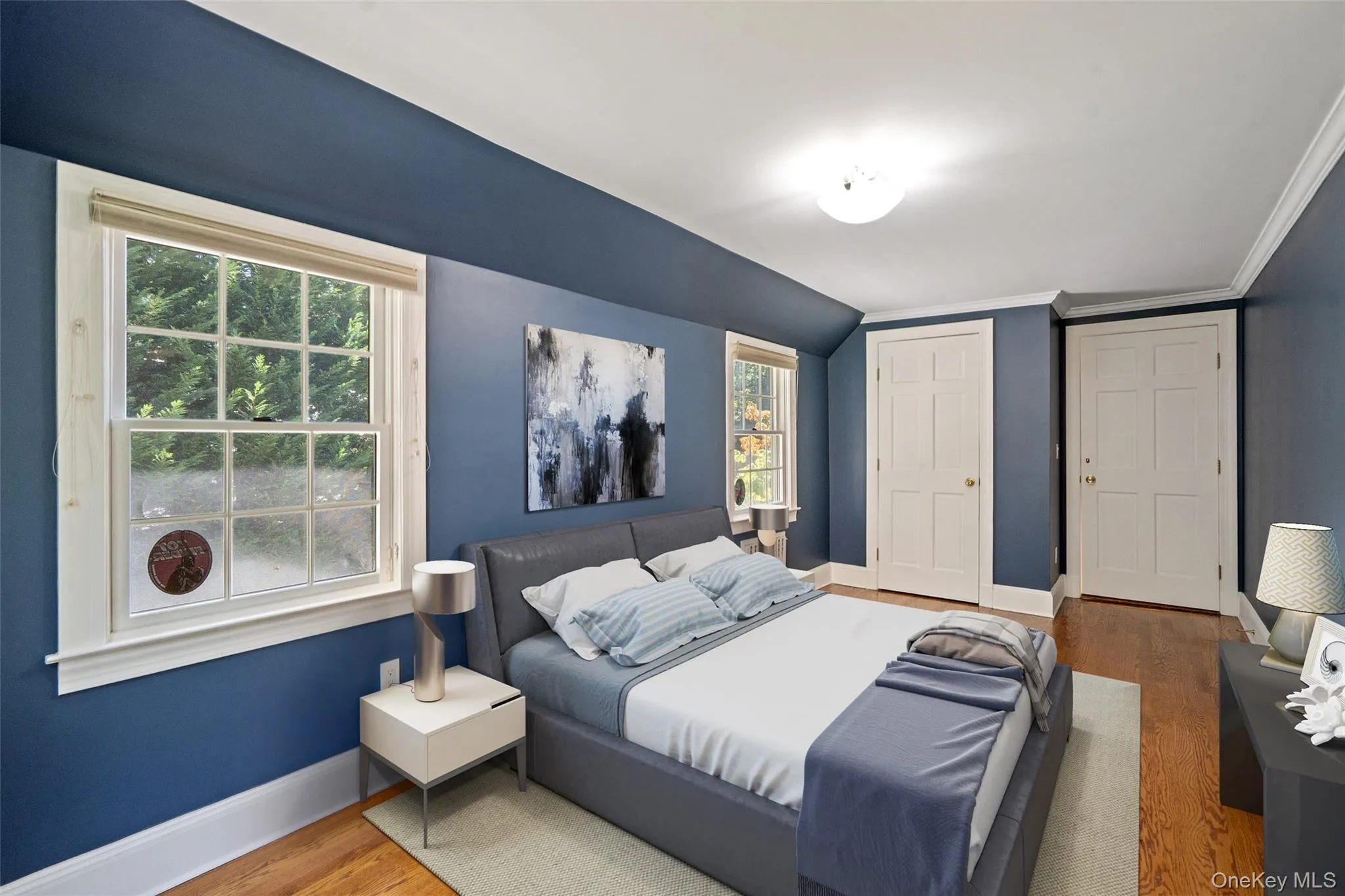 Bedroom with wood finished floors, a closet, lofted ceiling, and crown molding Bedroom with wood finished floors, a closet, lofted ceiling, and crown molding