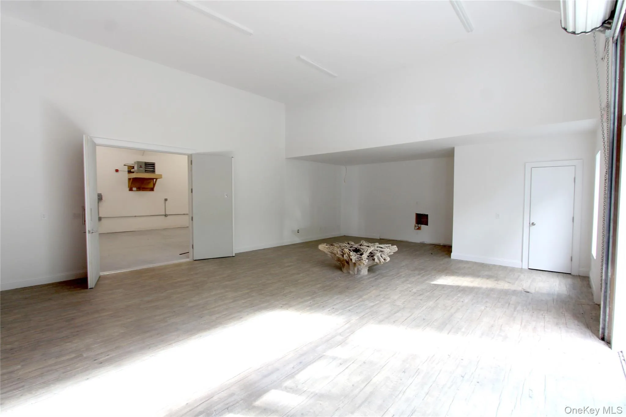 Additional living space with wood finished floors and a high ceiling Additional living space with wood finished floors and a high ceiling