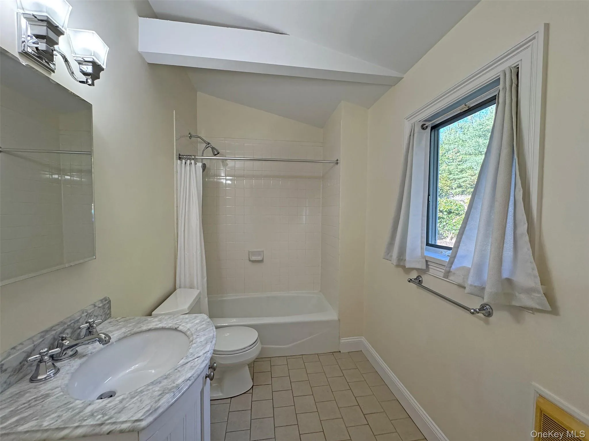 Full bath featuring lofted ceiling, vanity, and shower / bath combination with curtain Full bath featuring lofted ceiling, vanity, and shower / bath combination with curtain