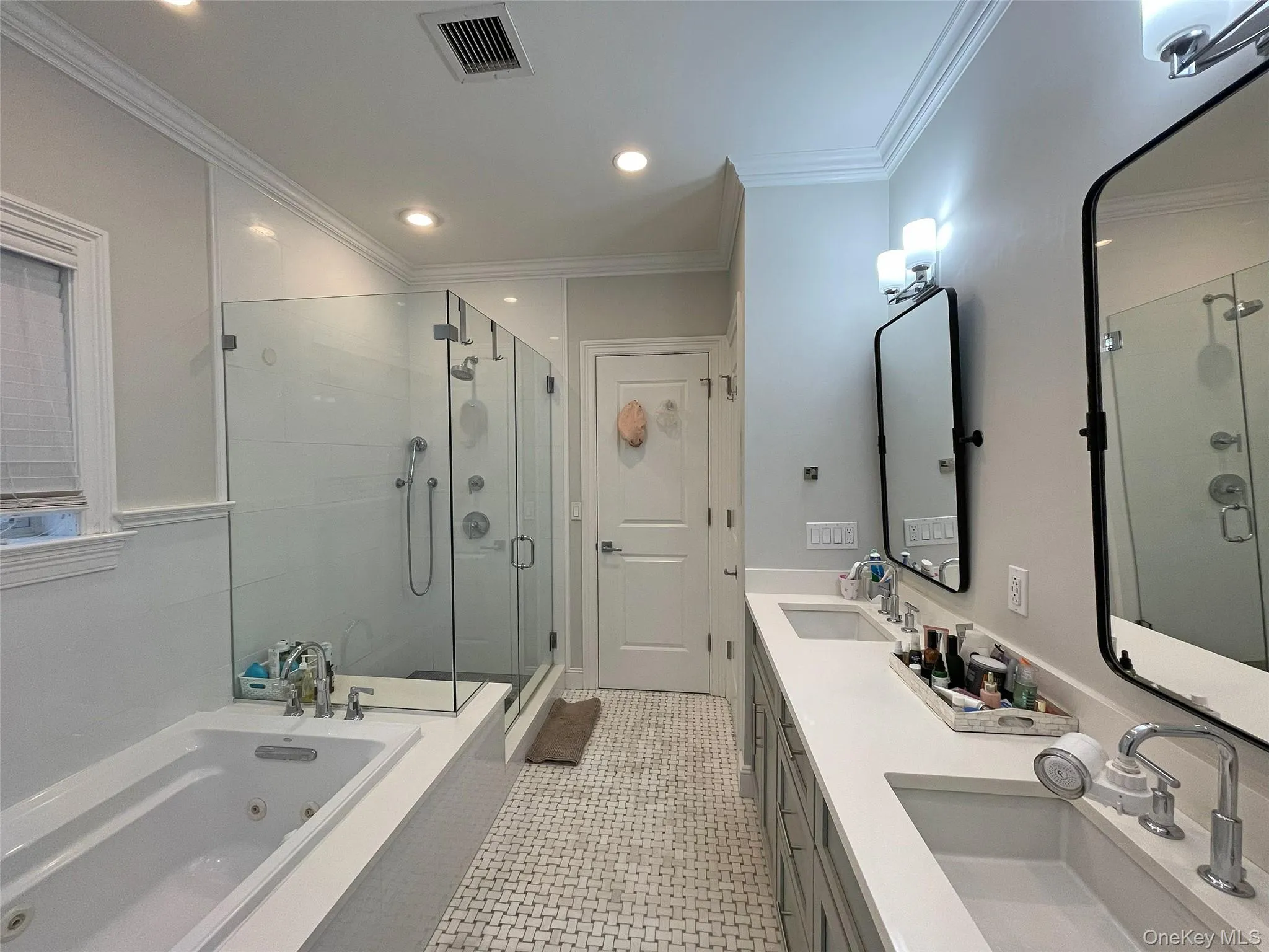 Bathroom with a tub with jets, double vanity, a shower stall, crown molding, and recessed lighting Bathroom with a tub with jets, double vanity, a shower stall, crown molding, and recessed lighting