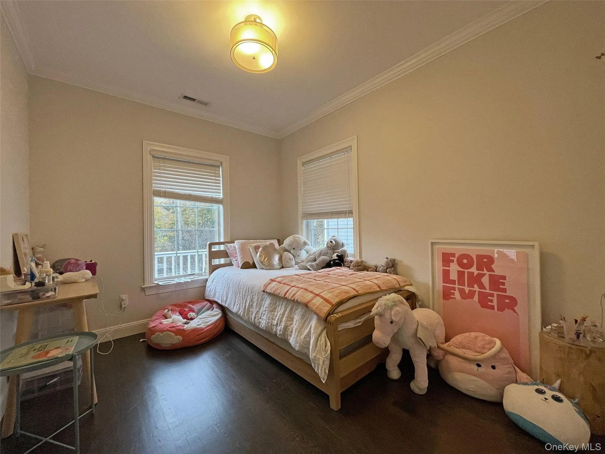 Bedroom with wood finished floors and ornamental molding Bedroom with wood finished floors and ornamental molding