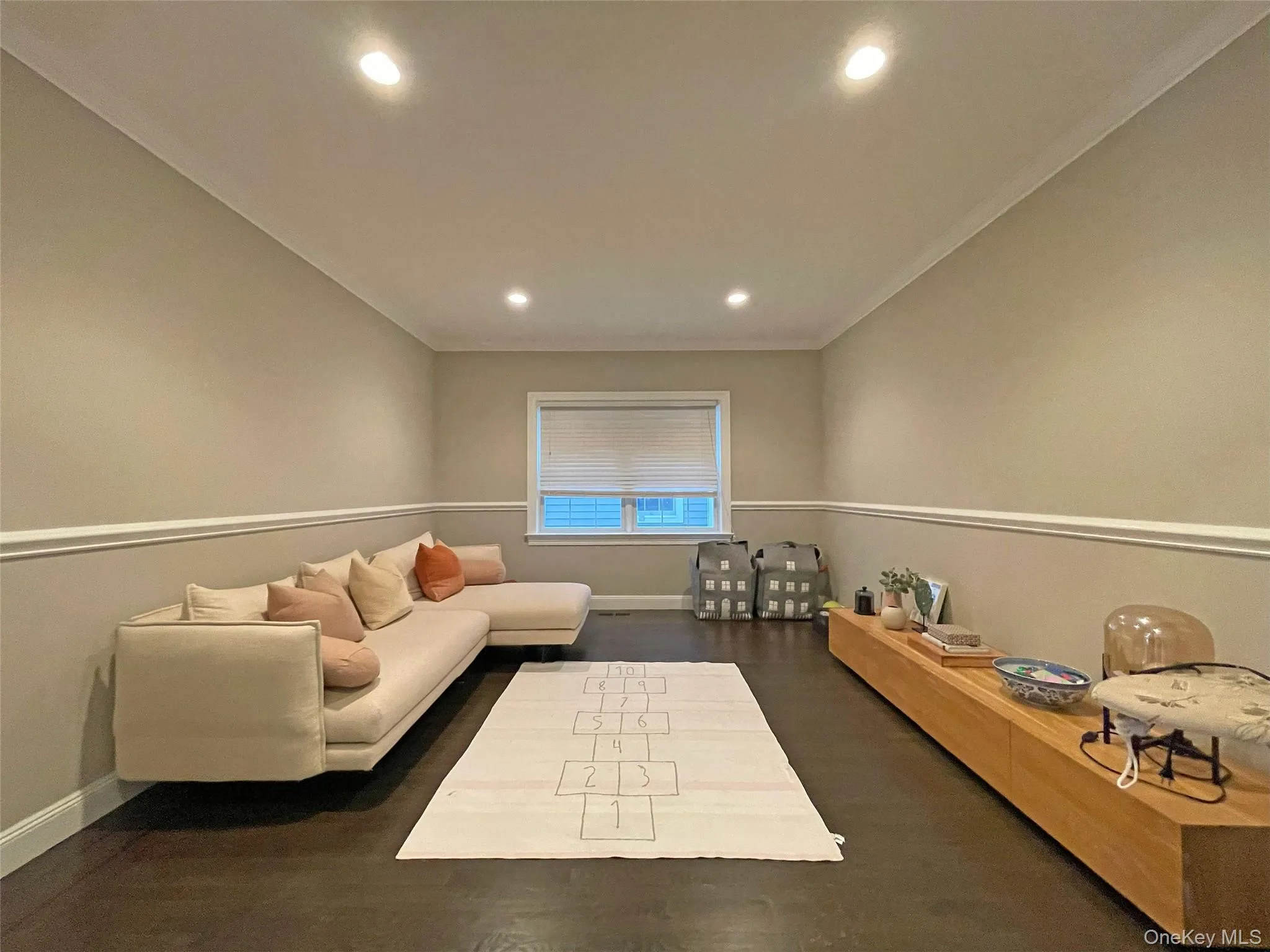 Living room with recessed lighting, dark wood-style floors, and crown molding Living room with recessed lighting, dark wood-style floors, and crown molding