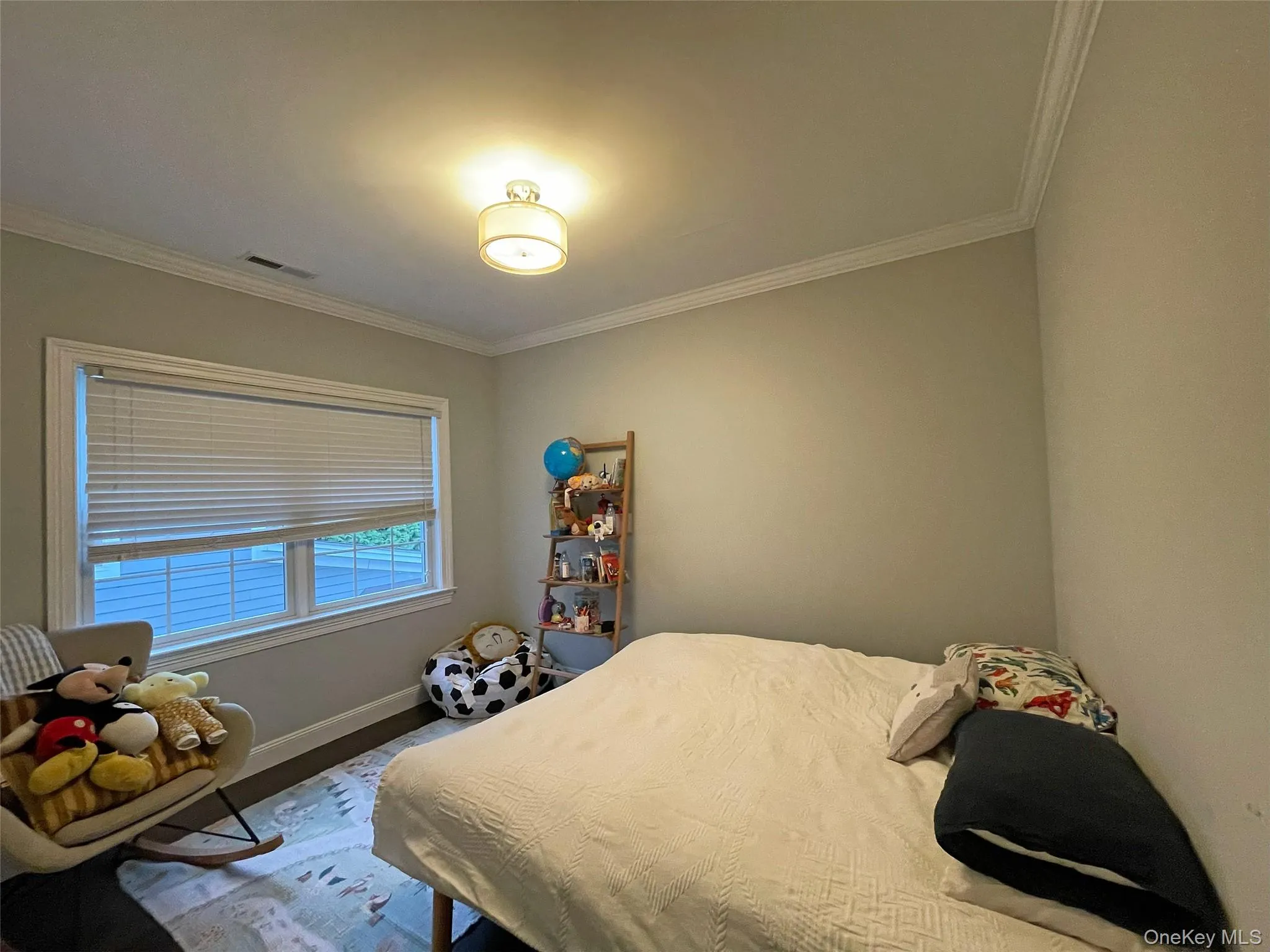 Bedroom featuring baseboards and crown molding Bedroom featuring baseboards and crown molding