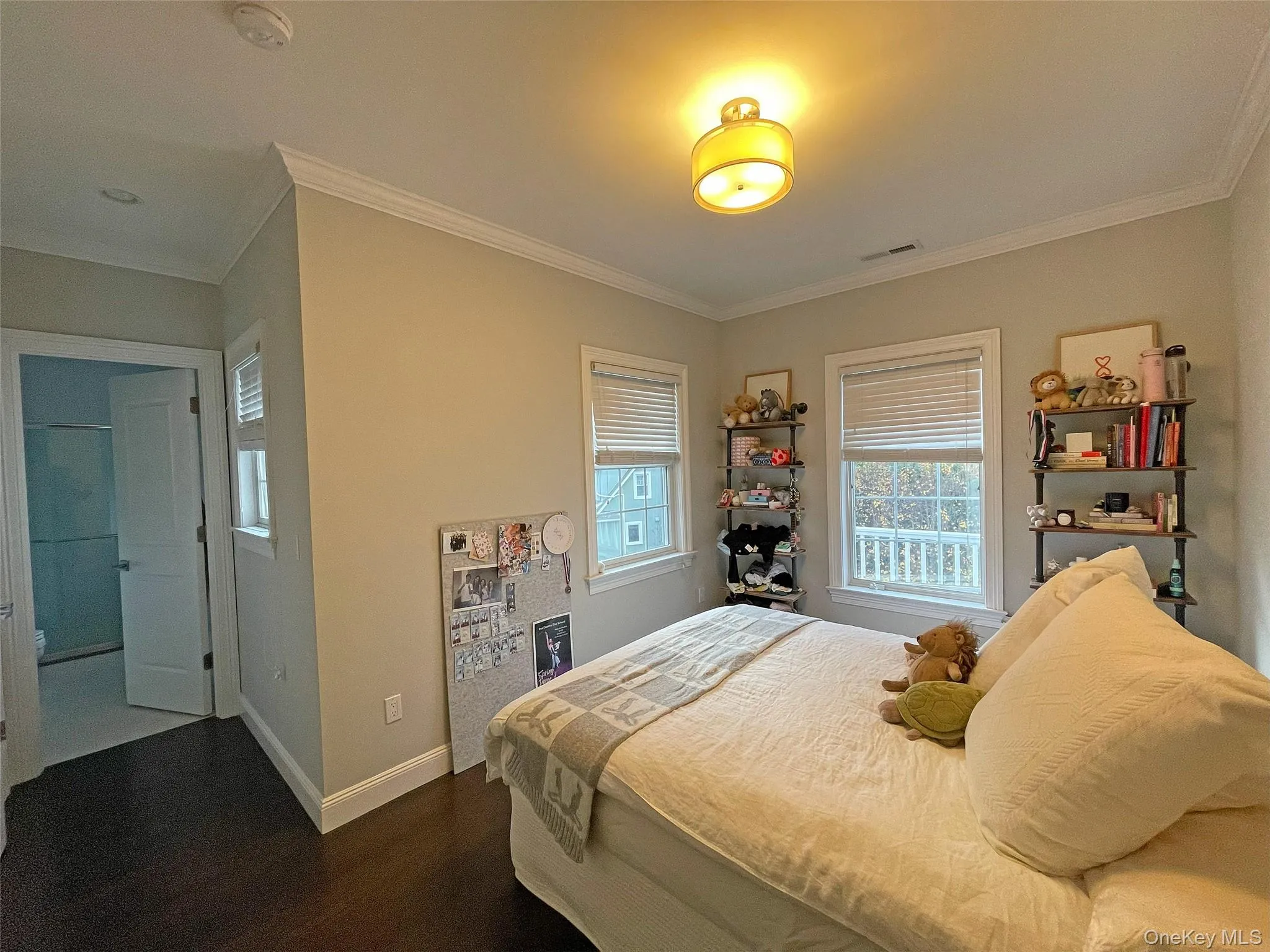 Bedroom featuring ornamental molding and dark wood finished floors Bedroom featuring ornamental molding and dark wood finished floors
