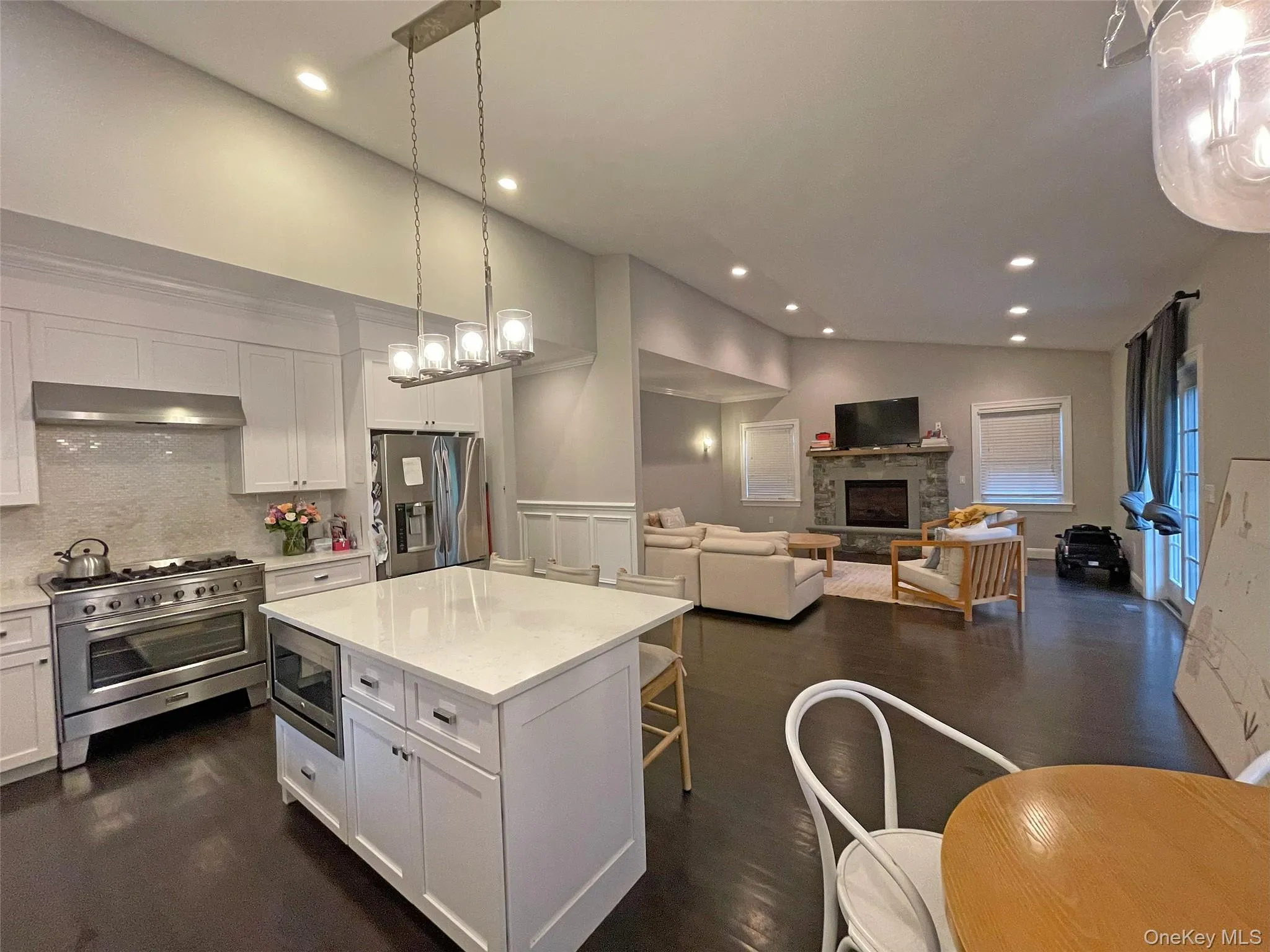Kitchen featuring decorative light fixtures, white cabinetry, open floor plan, appliances with stainless steel finishes, and recessed lighting Kitchen featuring decorative light fixtures, white cabinetry, open floor plan, appliances with stainless steel finishes, and recessed lighting