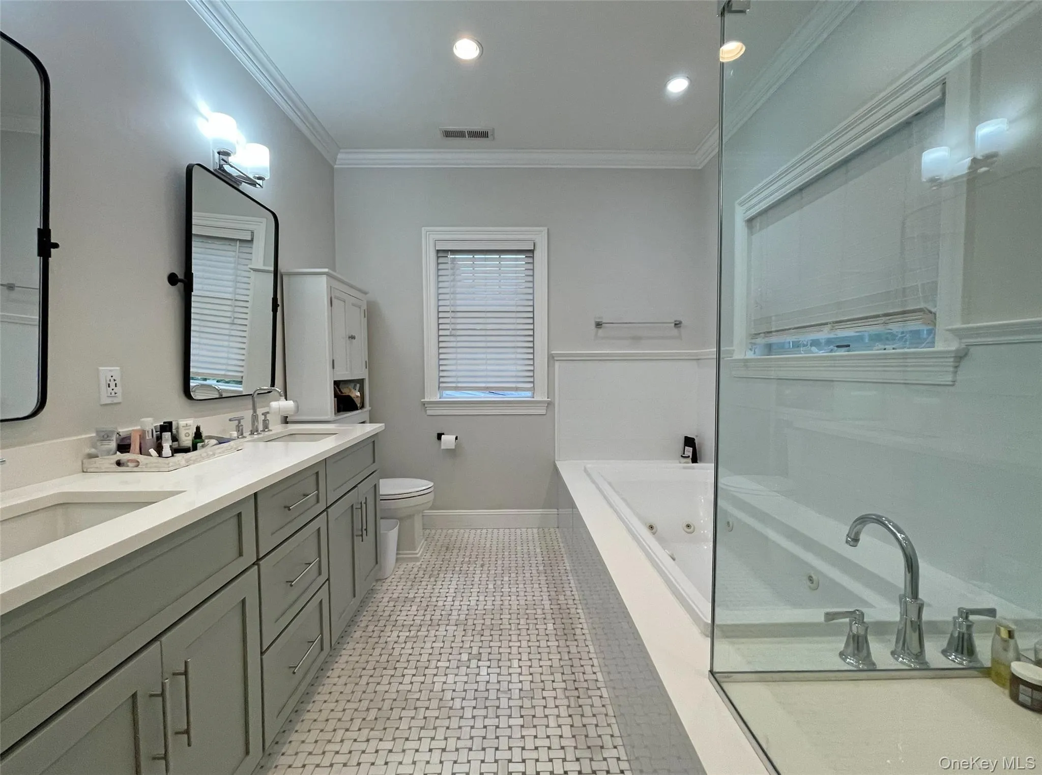 Full bath featuring a jetted tub, double vanity, recessed lighting, crown molding, and light tile patterned flooring Full bath featuring a jetted tub, double vanity, recessed lighting, crown molding, and light tile patterned flooring