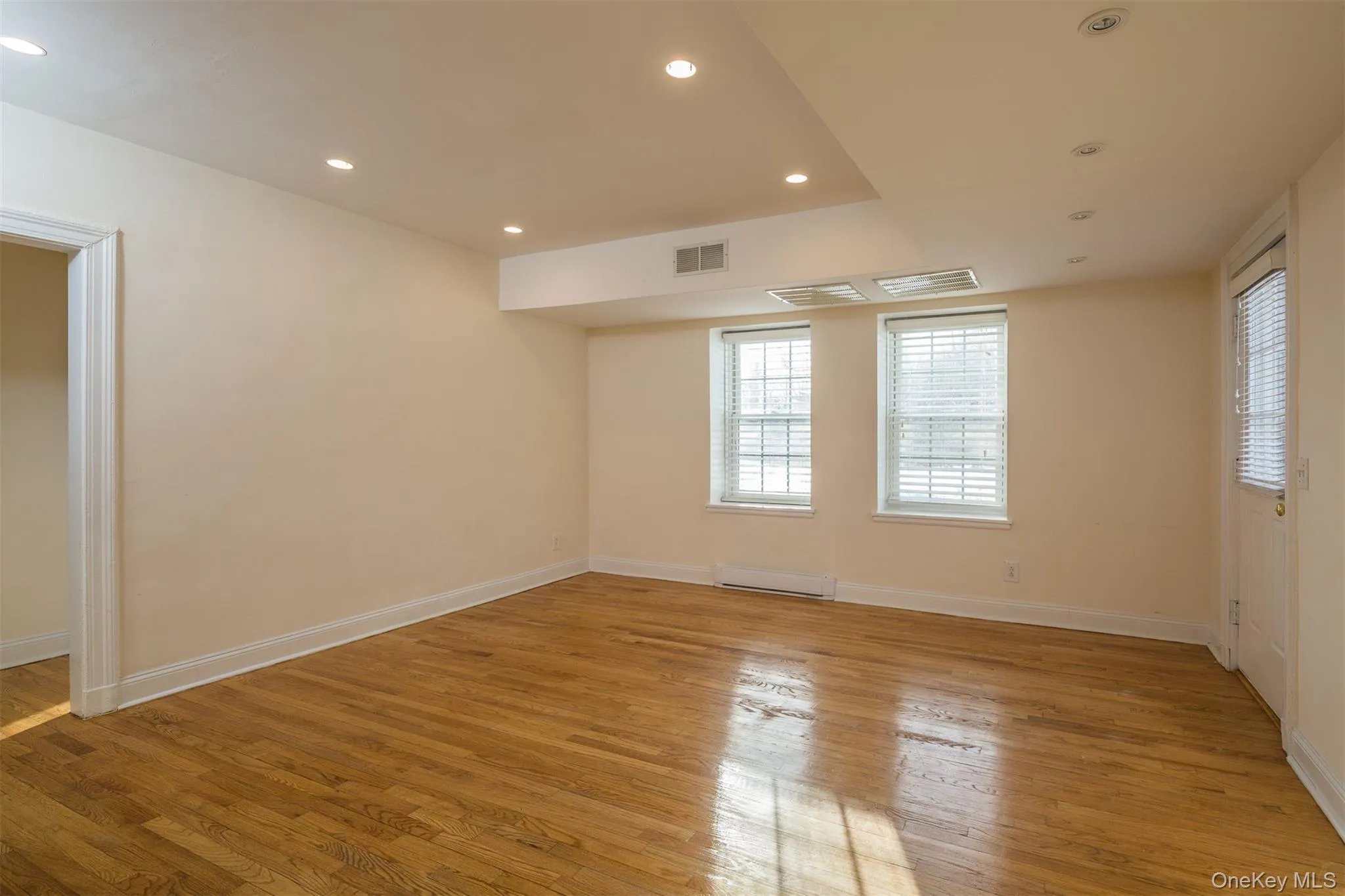 Spare room with recessed lighting, light wood-style floors, and a baseboard heating unit Spare room with recessed lighting, light wood-style floors, and a baseboard heating unit
