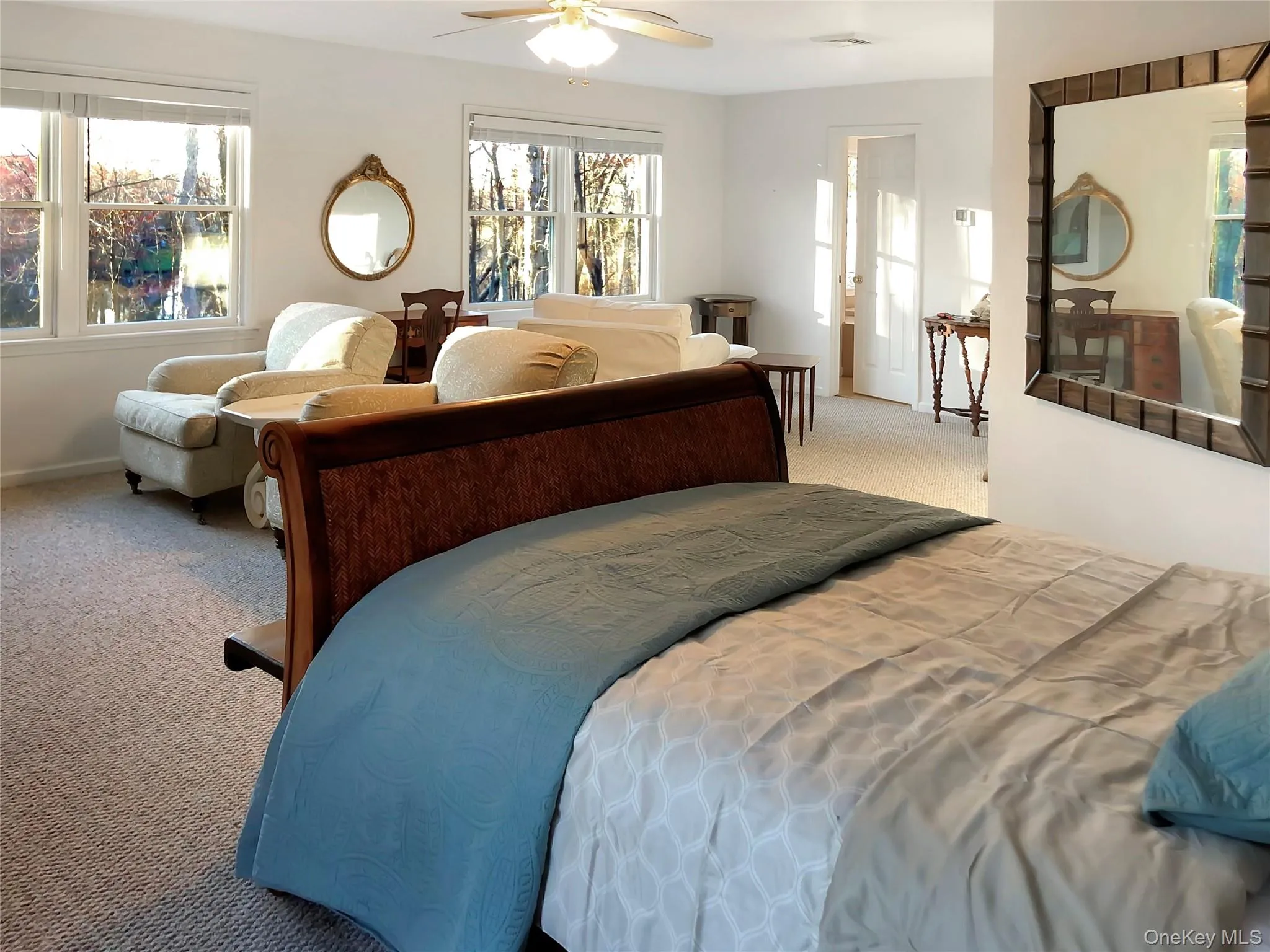 Bedroom featuring carpet, multiple windows, and ceiling fan Bedroom featuring carpet, multiple windows, and ceiling fan