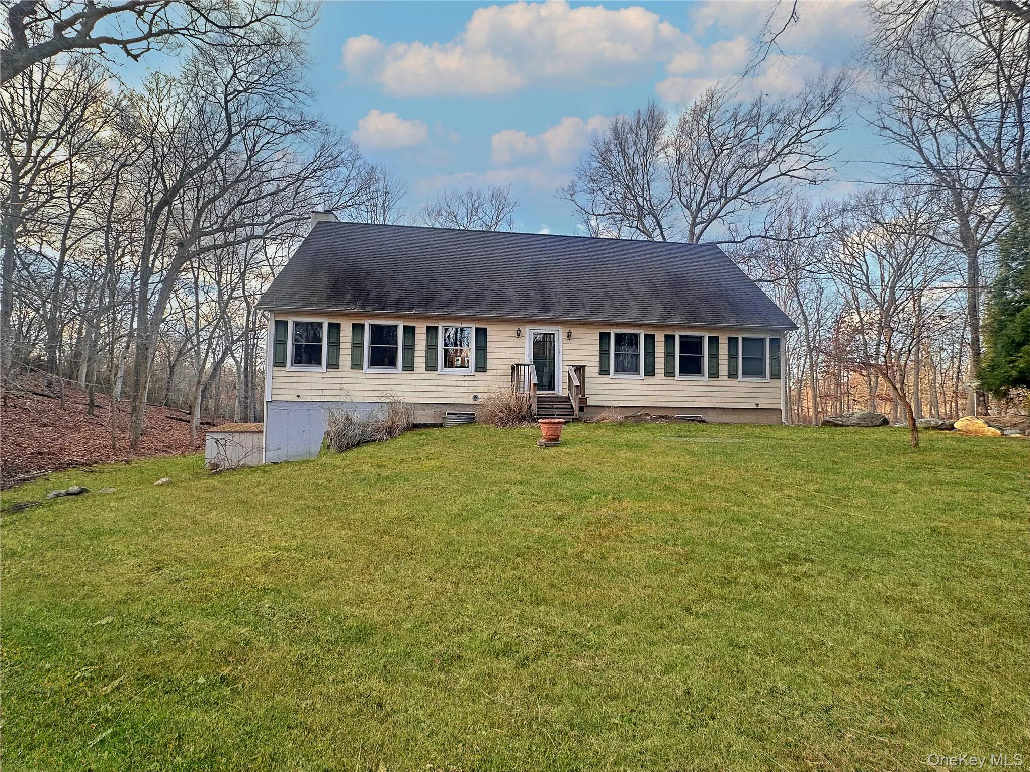 View of front facade featuring a front yard, a shingled roof, and entry steps View of front facade featuring a front yard, a shingled roof, and entry steps