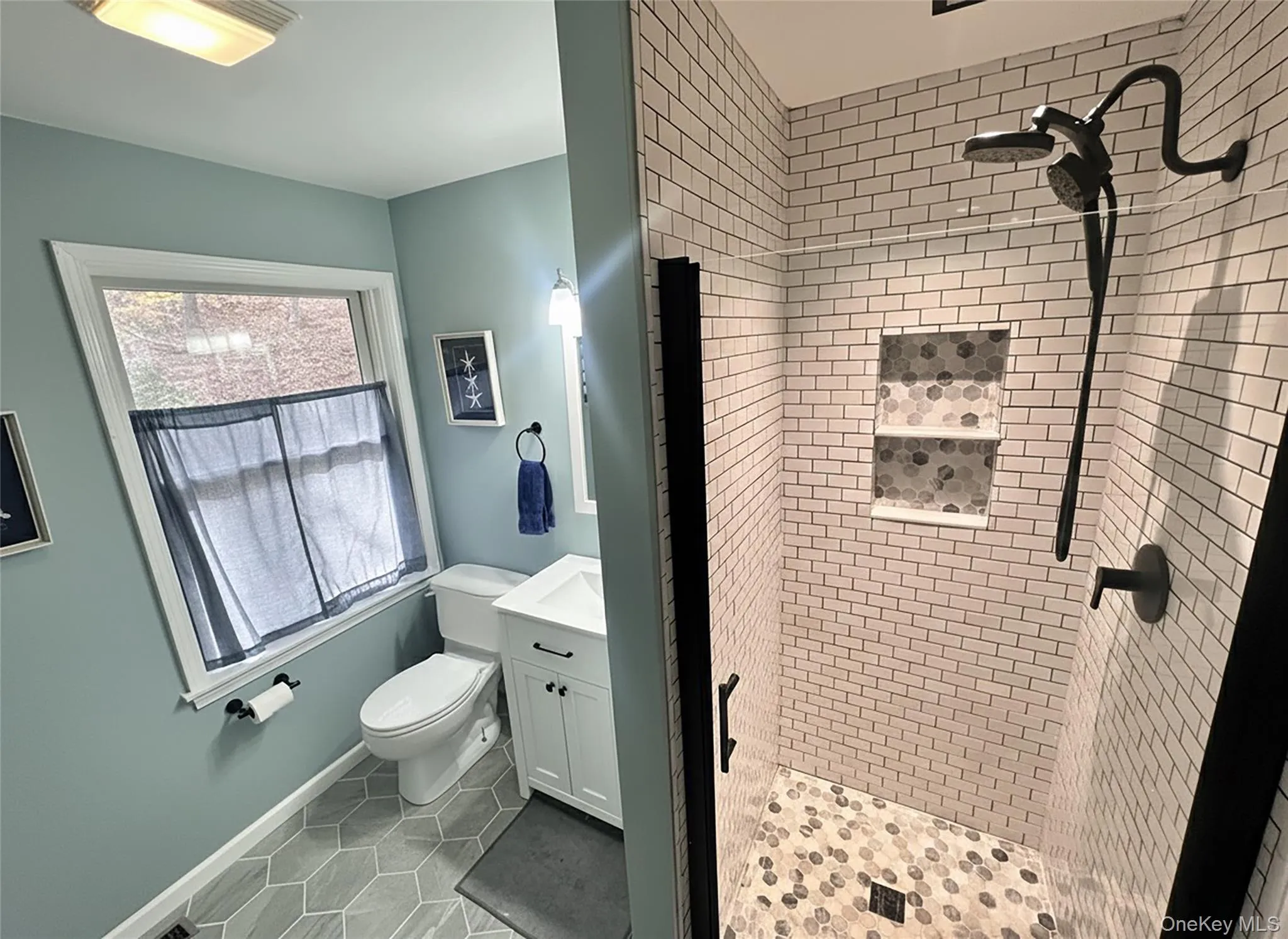 Full bathroom with a shower stall, light tile patterned flooring, and vanity Full bathroom with a shower stall, light tile patterned flooring, and vanity