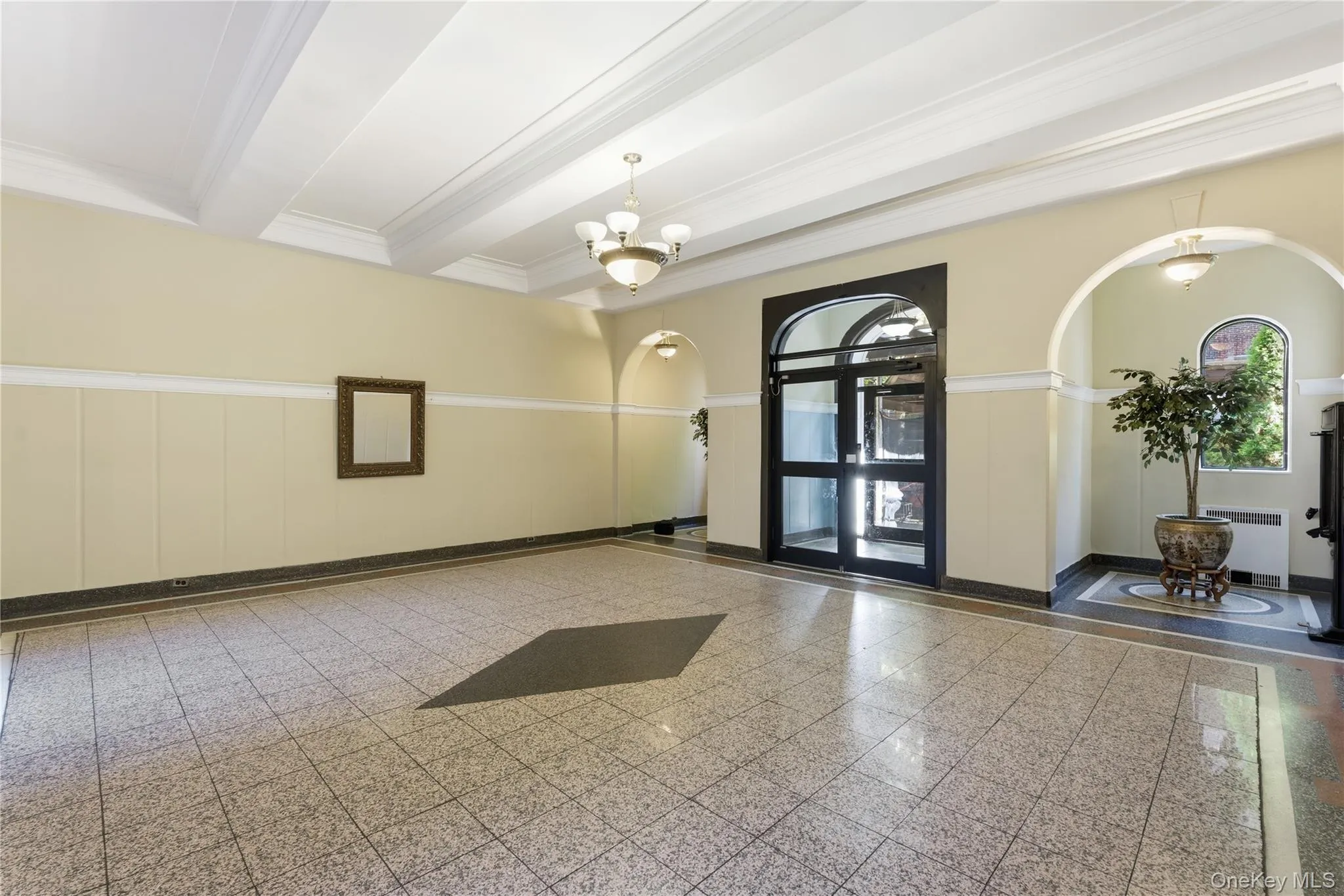 Lobby featuring beamed ceiling, ornamental molding, a wainscoted wall, and a decorative wall Lobby featuring beamed ceiling, ornamental molding, a wainscoted wall, and a decorative wall