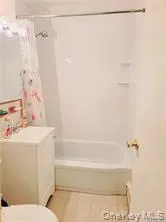 Bathroom with shower / washtub combination, vanity, and light tile patterned floors Bathroom with shower / washtub combination, vanity, and light tile patterned floors