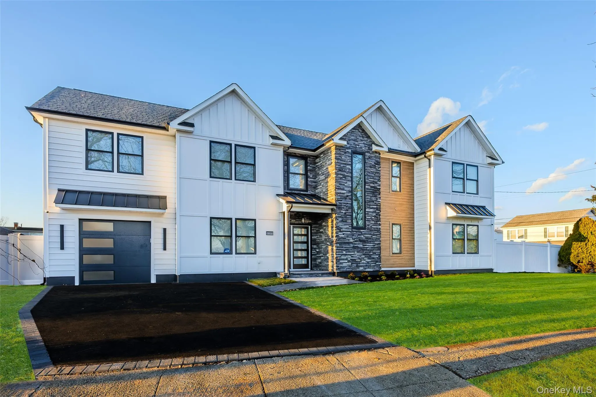 Modern inspired farmhouse with a standing seam roof, a metal roof, and board and batten siding Modern inspired farmhouse with a standing seam roof, a metal roof, and board and batten siding