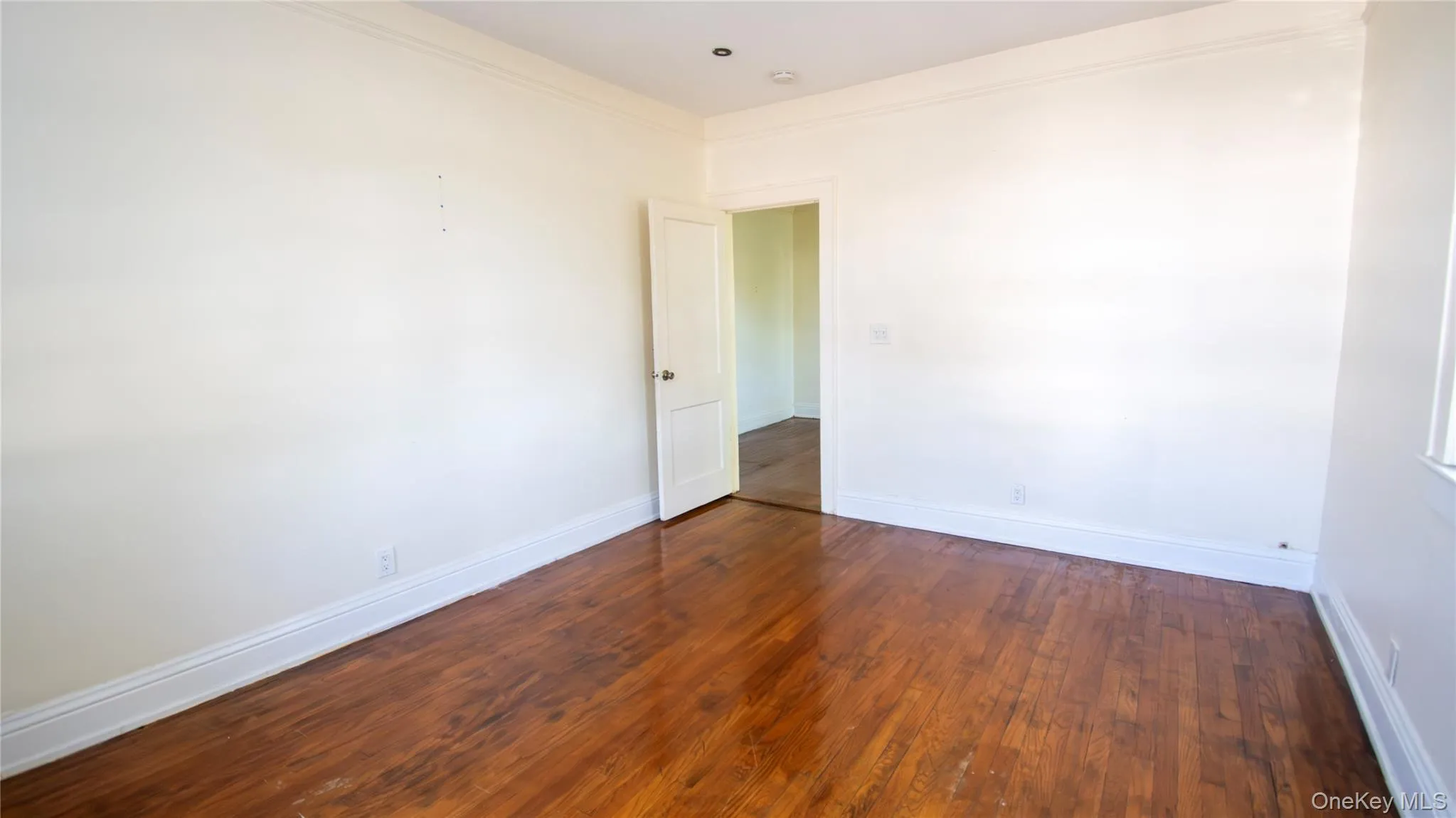 Unfurnished room with dark wood-type flooring and crown molding Unfurnished room with dark wood-type flooring and crown molding