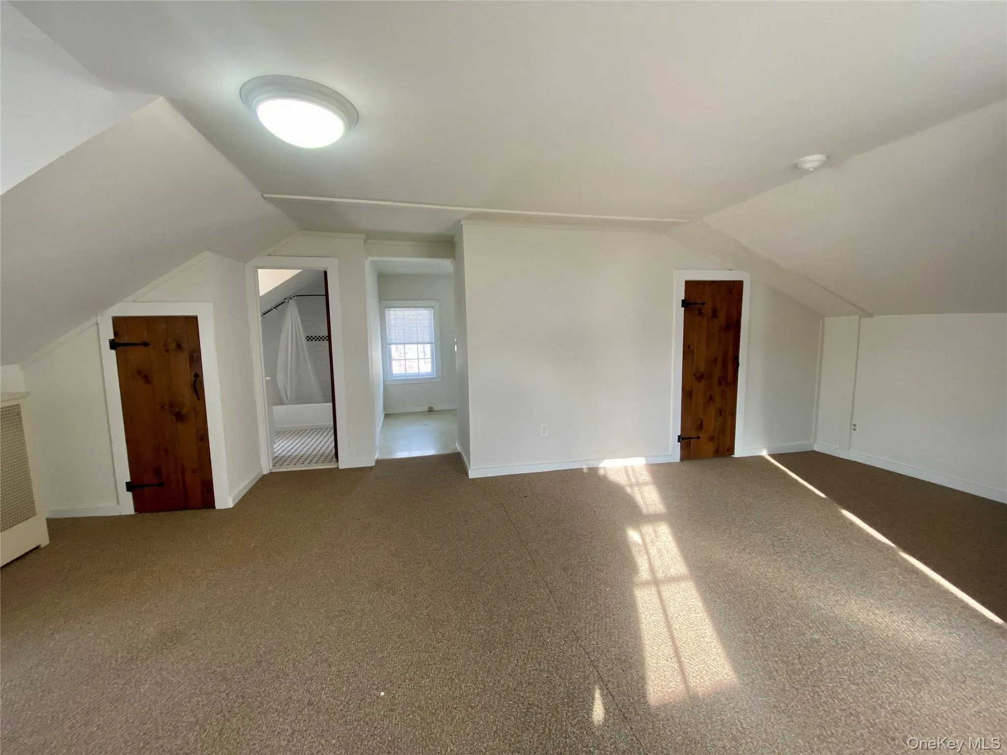 Additional living space with lofted ceiling and carpet floors Additional living space with lofted ceiling and carpet floors