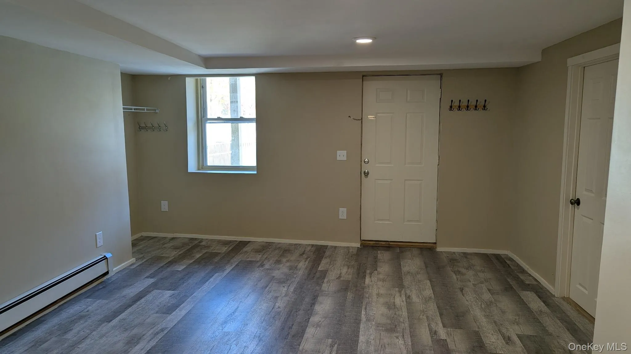 Empty room featuring baseboard heating, wood finished floors, and recessed lighting Empty room featuring baseboard heating, wood finished floors, and recessed lighting