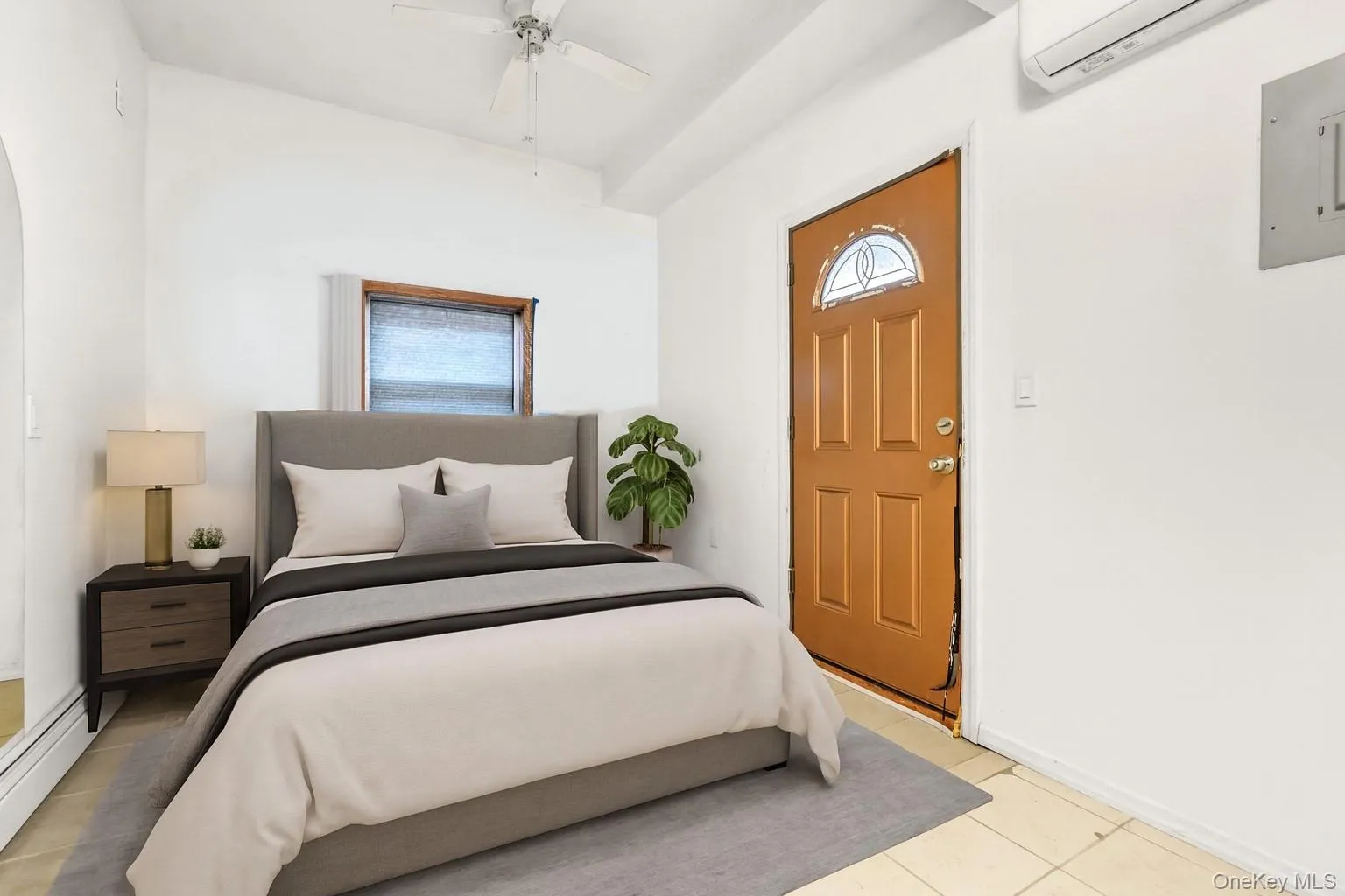 Tiled bedroom with multiple windows, electric panel, a wall unit AC, and ceiling fan Tiled bedroom with multiple windows, electric panel, a wall unit AC, and ceiling fan
