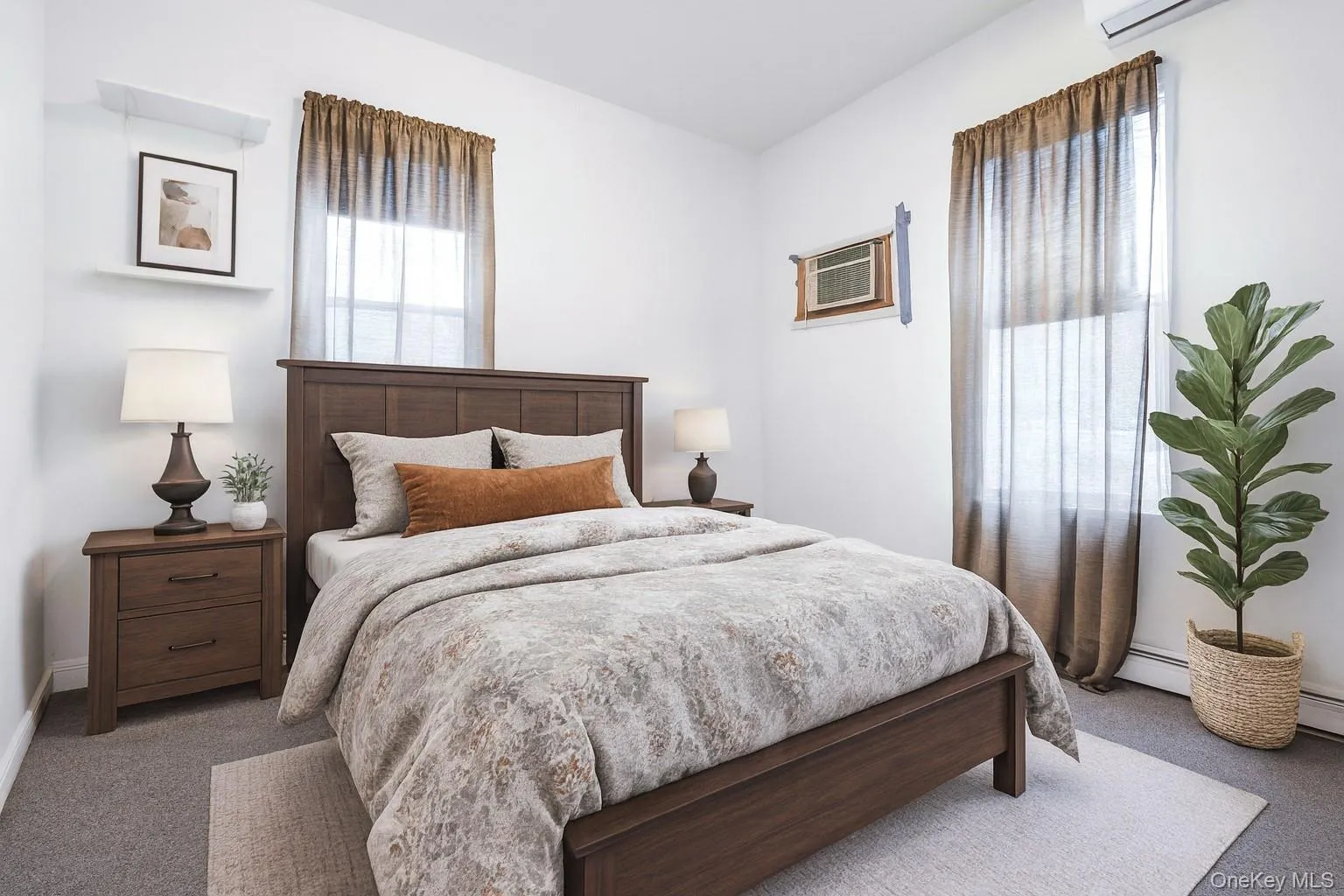 Carpeted bedroom with a baseboard heating unit and a wall mounted air conditioner Carpeted bedroom with a baseboard heating unit and a wall mounted air conditioner