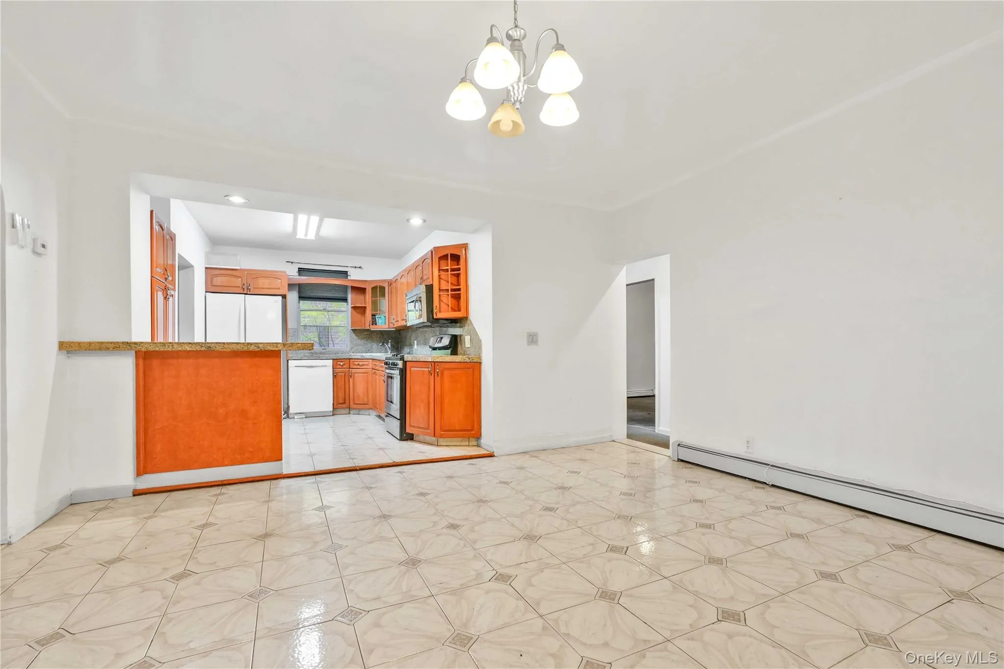 Kitchen with brown cabinets, glass insert cabinets, a chandelier, stainless steel appliances, and hanging light fixtures Kitchen with brown cabinets, glass insert cabinets, a chandelier, stainless steel appliances, and hanging light fixtures