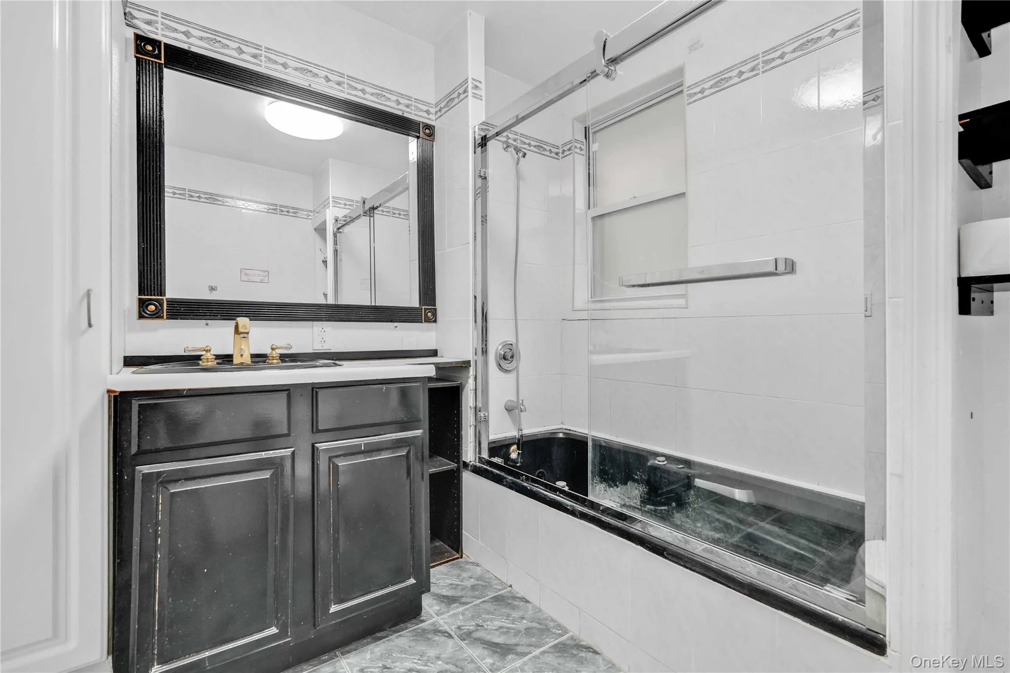 Bathroom with bath / shower combo with glass door and vanity Bathroom with bath / shower combo with glass door and vanity