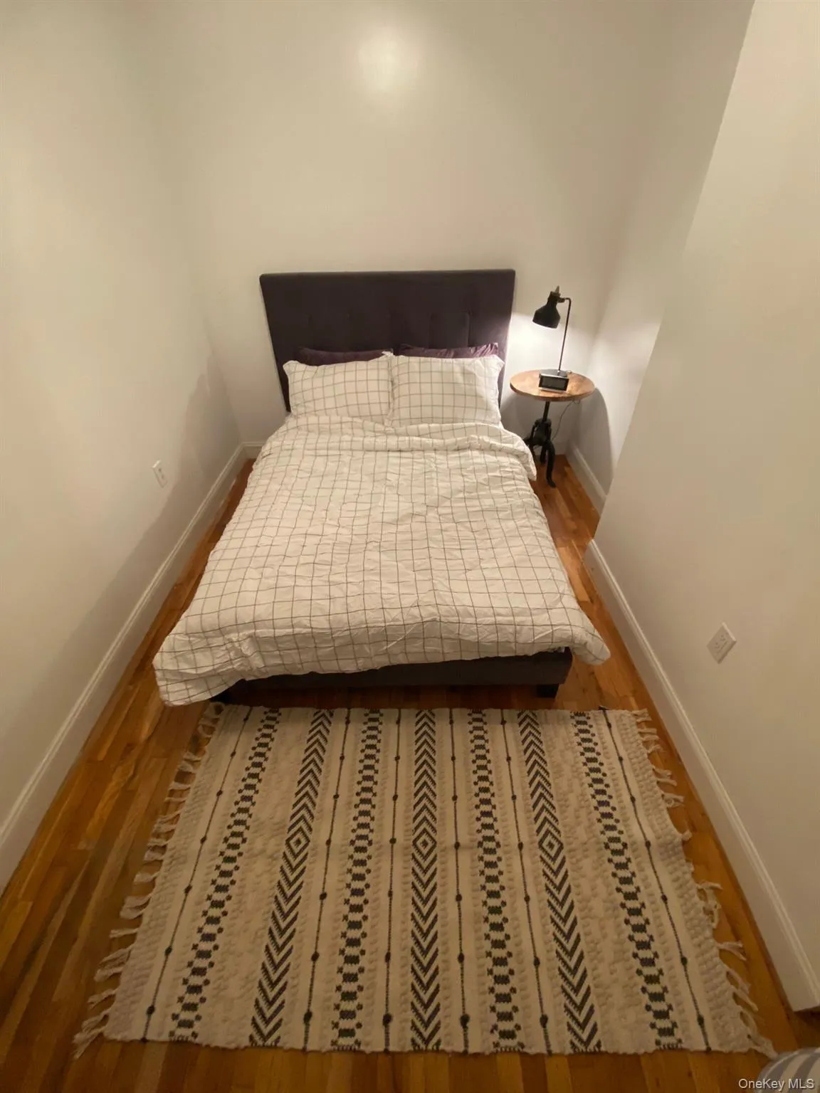Bedroom featuring baseboards and wood finished floors Bedroom featuring baseboards and wood finished floors