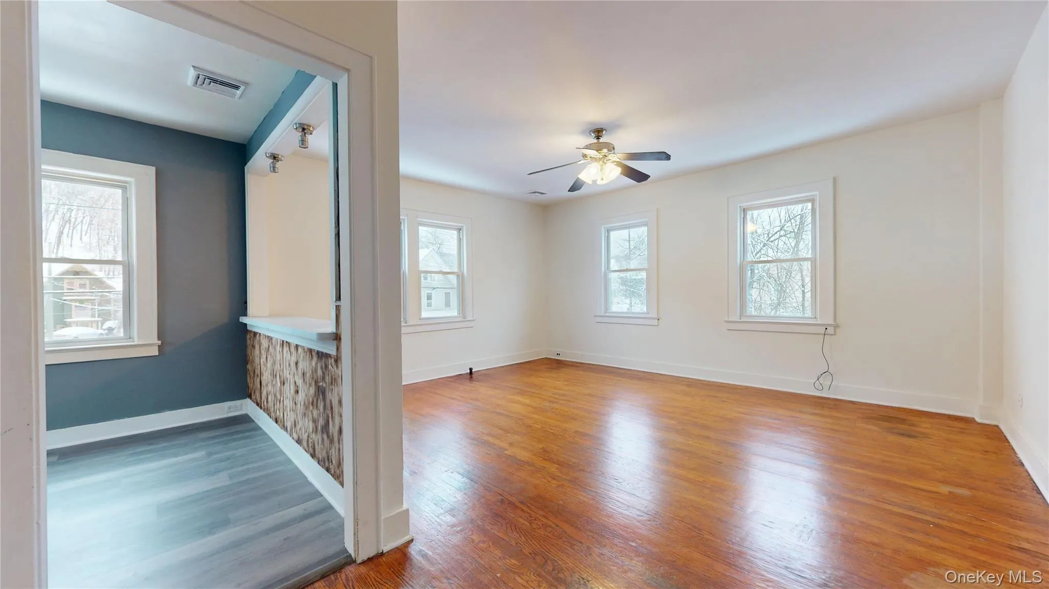 Empty room with wood finished floors and a ceiling fan Empty room with wood finished floors and a ceiling fan