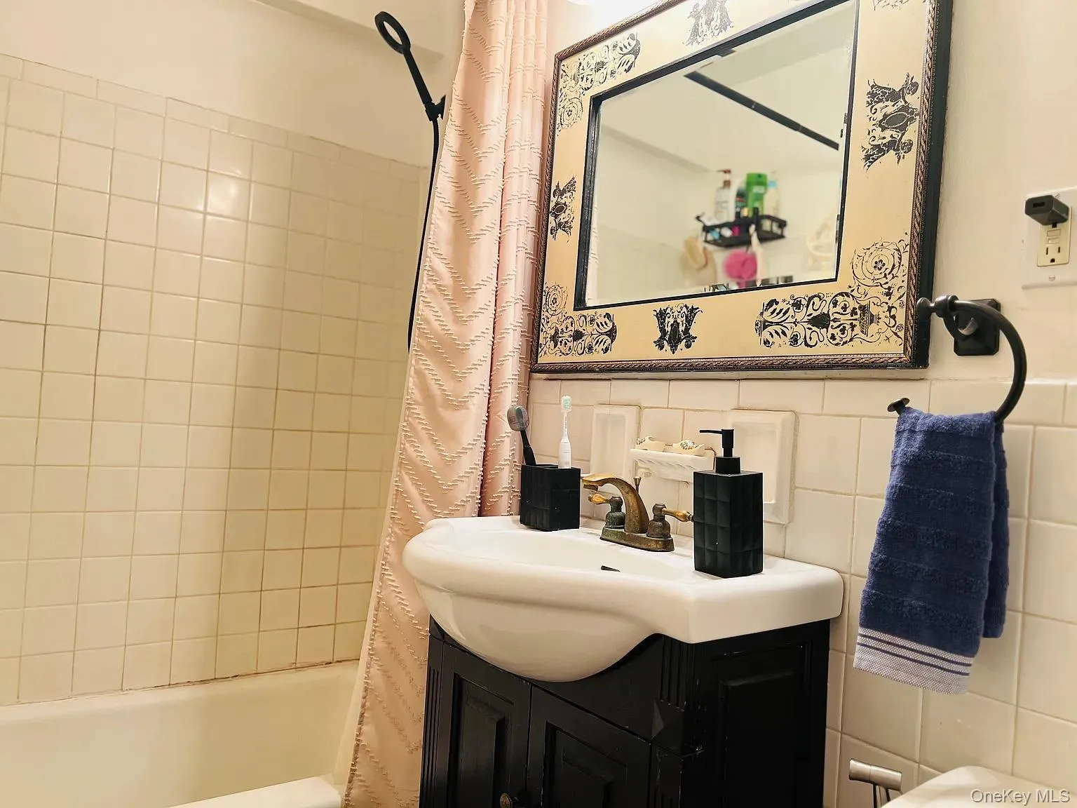 Full bathroom featuring vanity, shower / tub combo, and tile walls Full bathroom featuring vanity, shower / tub combo, and tile walls