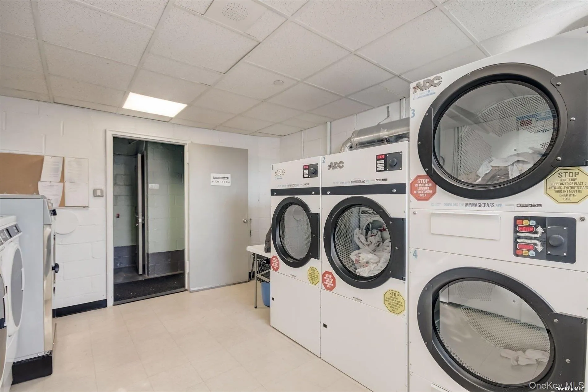 Communal laundry room with a drop ceiling, stacked washer / drying machine, and washer and dryer Communal laundry room with a drop ceiling, stacked washer / drying machine, and washer and dryer