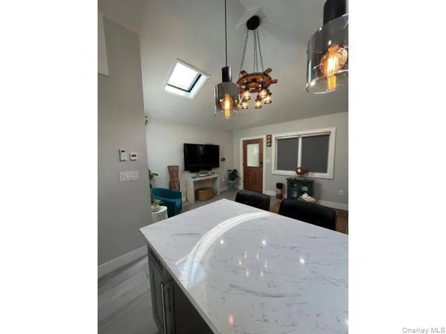 Bedroom featuring a skylight, a chandelier, and dark wood-style flooring Bedroom featuring a skylight, a chandelier, and dark wood-style flooring