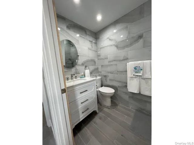 Bathroom featuring vanity and tile walls Bathroom featuring vanity and tile walls