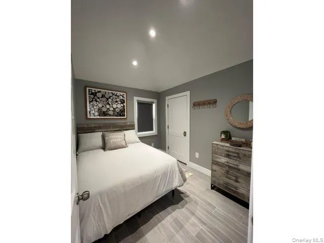 Bedroom with wood tiled floors, vaulted ceiling, and recessed lighting Bedroom with wood tiled floors, vaulted ceiling, and recessed lighting